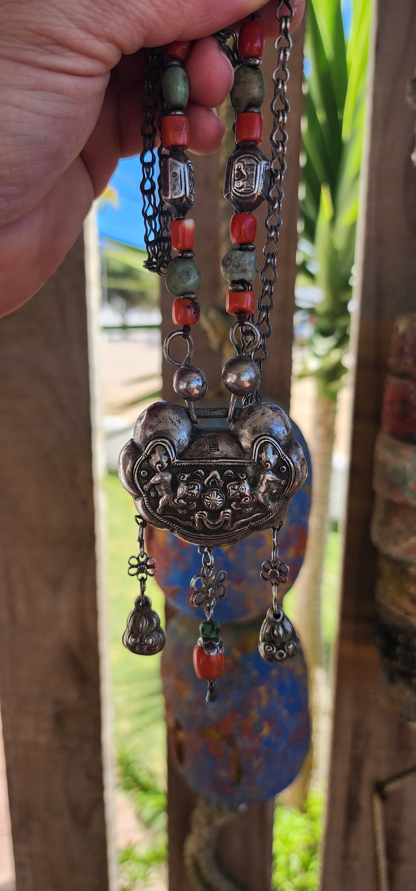 An extraordinary and highly collectible antique Chinese Qing Dynasty sterling silver “Longevity Lock” rattle pendant necklace, lavishly embellished with turquoise and coral bead accents and ornate dangle charms.