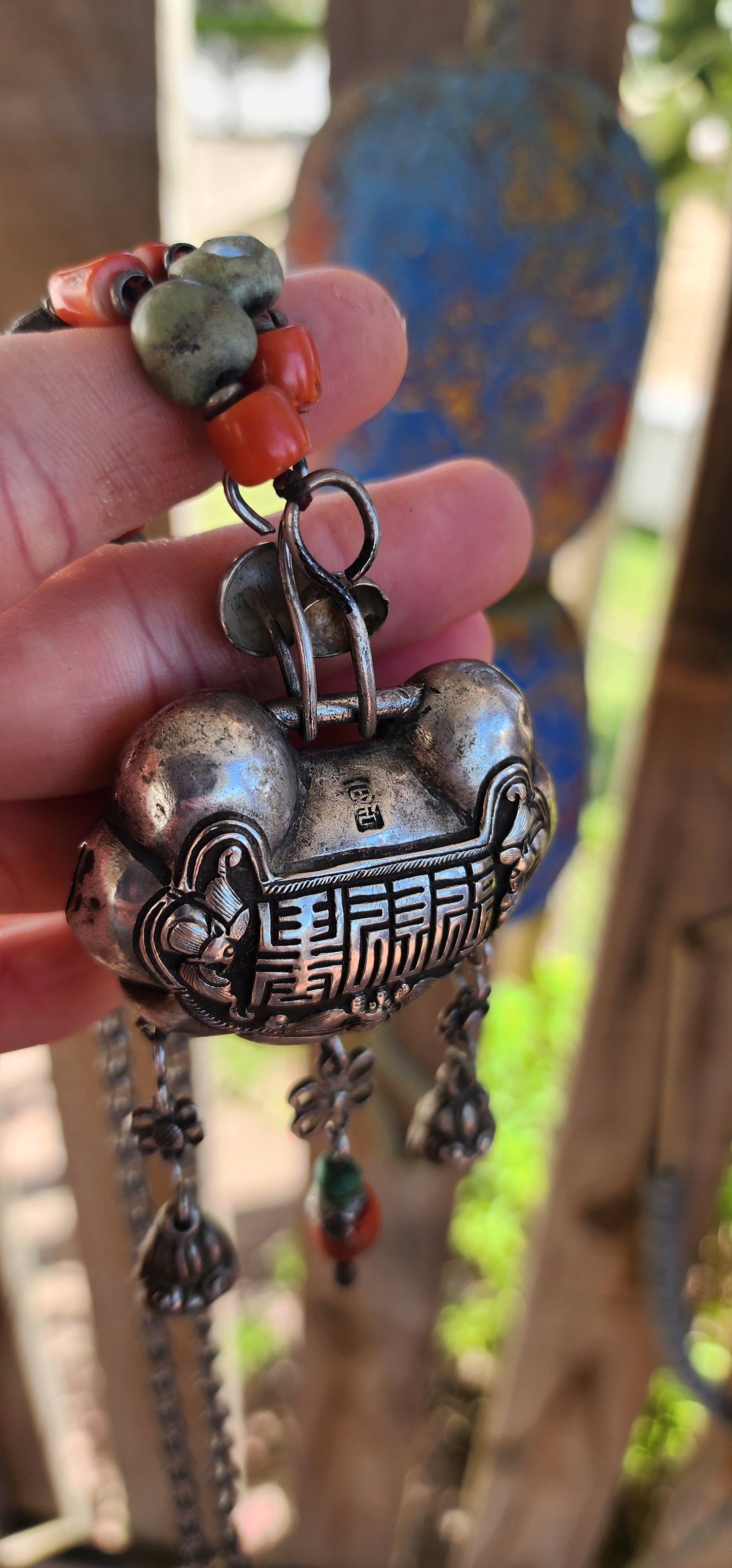 An extraordinary and highly collectible antique Chinese Qing Dynasty sterling silver “Longevity Lock” rattle pendant necklace, lavishly embellished with turquoise and coral bead accents and ornate dangle charms.