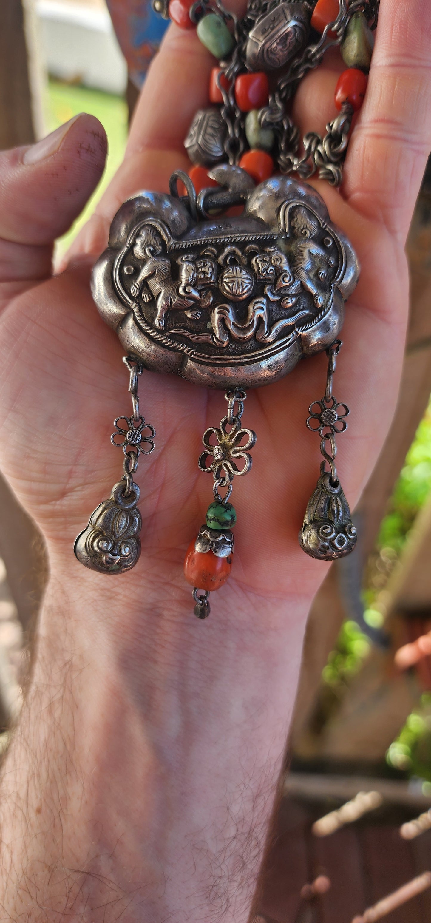 An extraordinary and highly collectible antique Chinese Qing Dynasty sterling silver “Longevity Lock” rattle pendant necklace, lavishly embellished with turquoise and coral bead accents and ornate dangle charms.