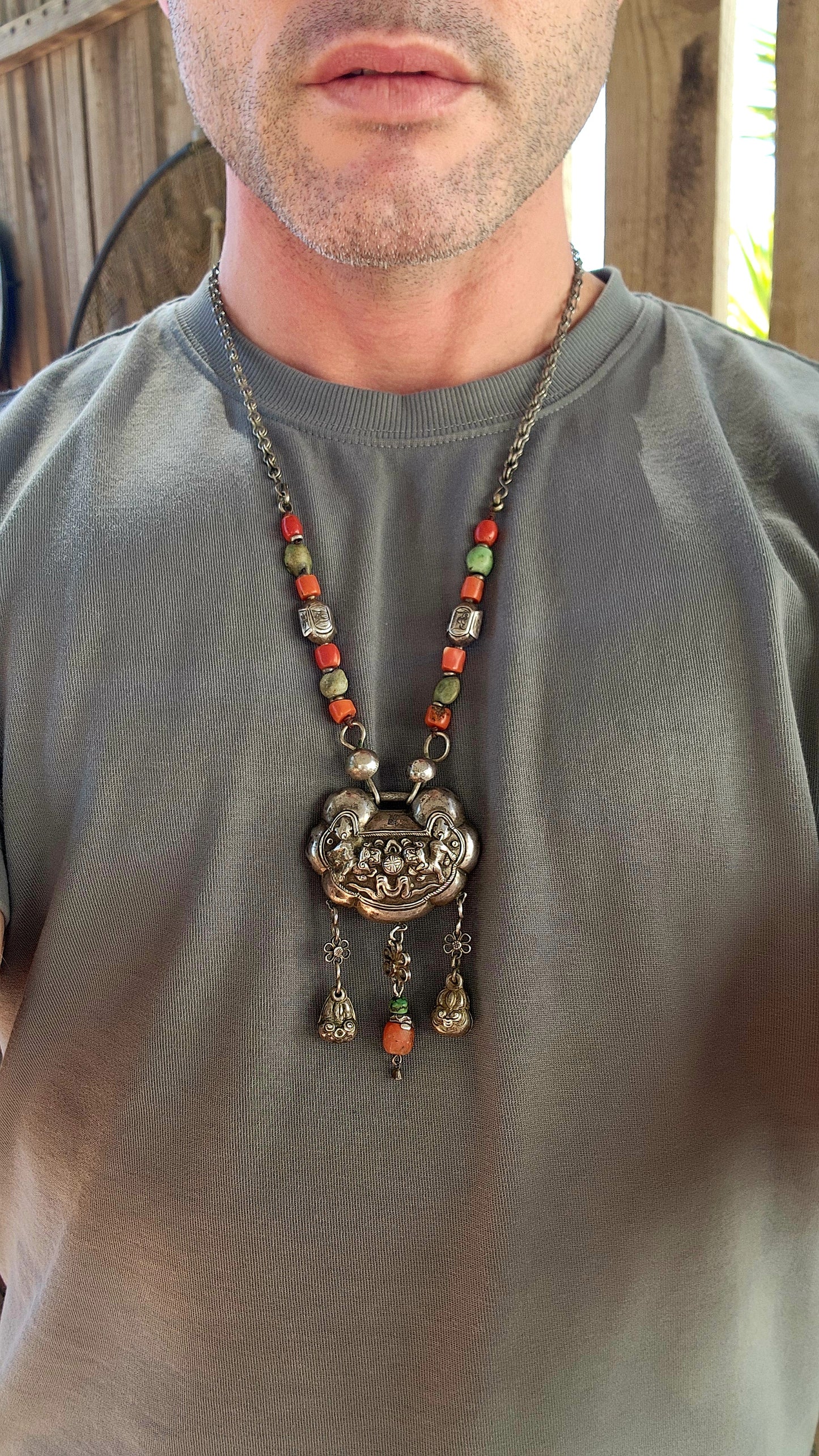 An extraordinary and highly collectible antique Chinese Qing Dynasty sterling silver “Longevity Lock” rattle pendant necklace, lavishly embellished with turquoise and coral bead accents and ornate dangle charms.