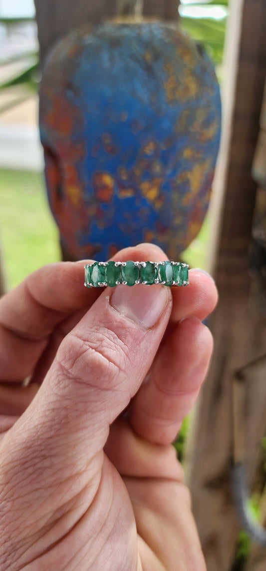 This glorious unisex sterling silver full eternity ring is a never-ending parade of 18 glowing oval-cut emeralds.