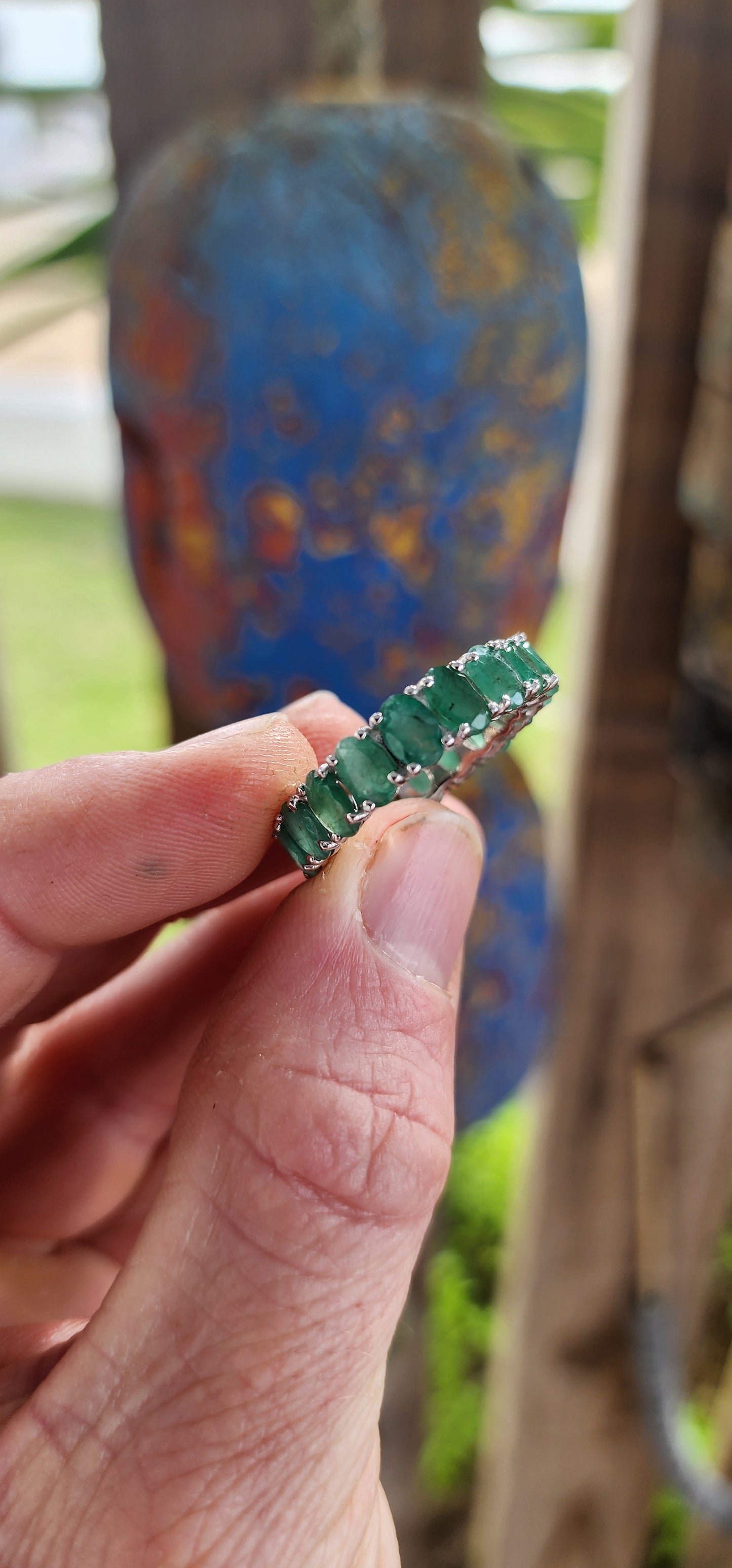 This glorious unisex sterling silver full eternity ring is a never-ending parade of 18 glowing oval-cut emeralds.