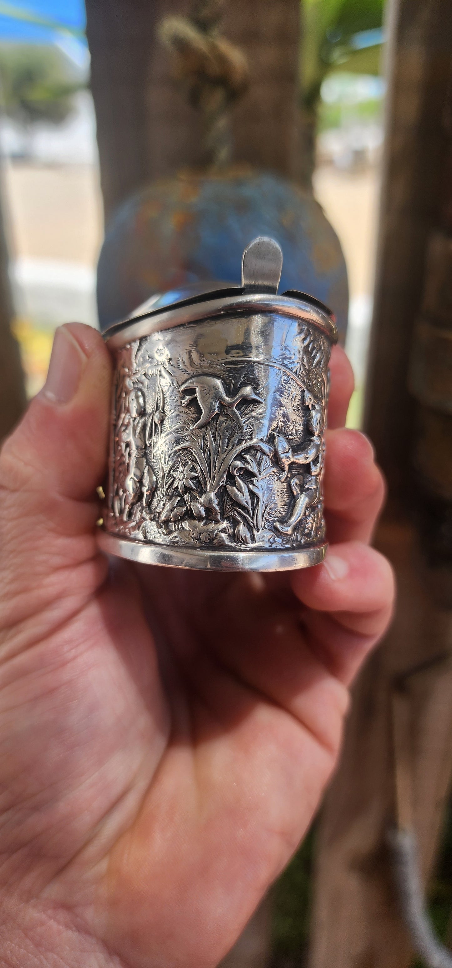 A beautiful example of Edwardian fascination with the “mystique of the East,” this circa 1902 hallmarked sterling silver mustard pot is richly cast in high relief with scenes of traditional life.
