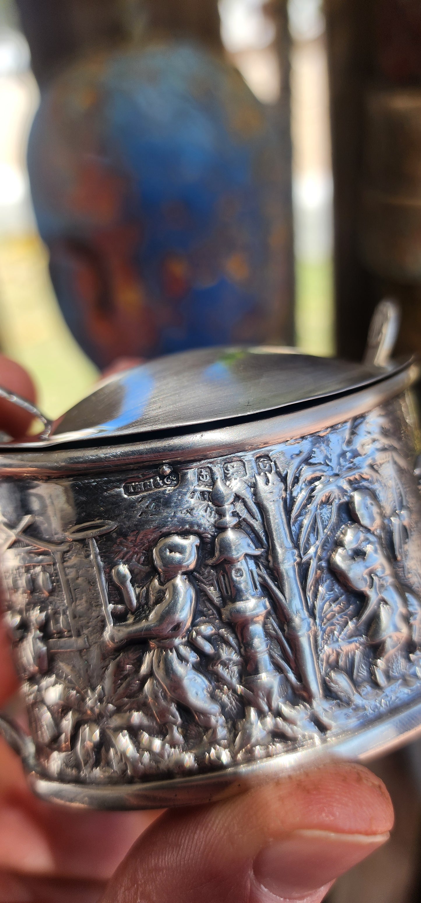 A beautiful example of Edwardian fascination with the “mystique of the East,” this circa 1902 hallmarked sterling silver mustard pot is richly cast in high relief with scenes of traditional life.