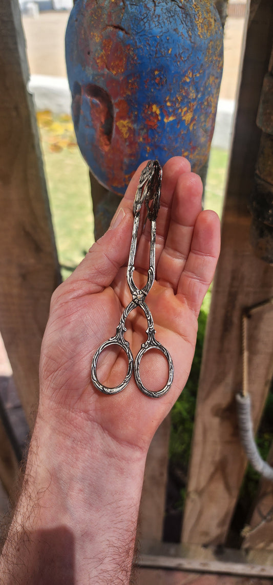 A charming vintage .800 silver pastry tongs, richly decorated in the romantic Art Nouveau style.