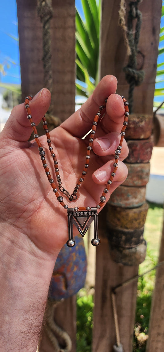 A striking vintage ethnic/tribal Amazigh (Berber / Tuareg) talismanic necklace from North Africa. The strand is composed of natural salmon-toned coral tube beads interspaced with hand-made spherical sterling silver beads.
