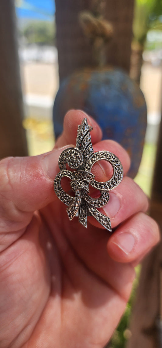 A charming whisper of the Art Deco age, this dainty circa 1930s sterling silver ribbon style brooch captures the era’s love of glamour and sculptural elegance in a beautifully petite format.