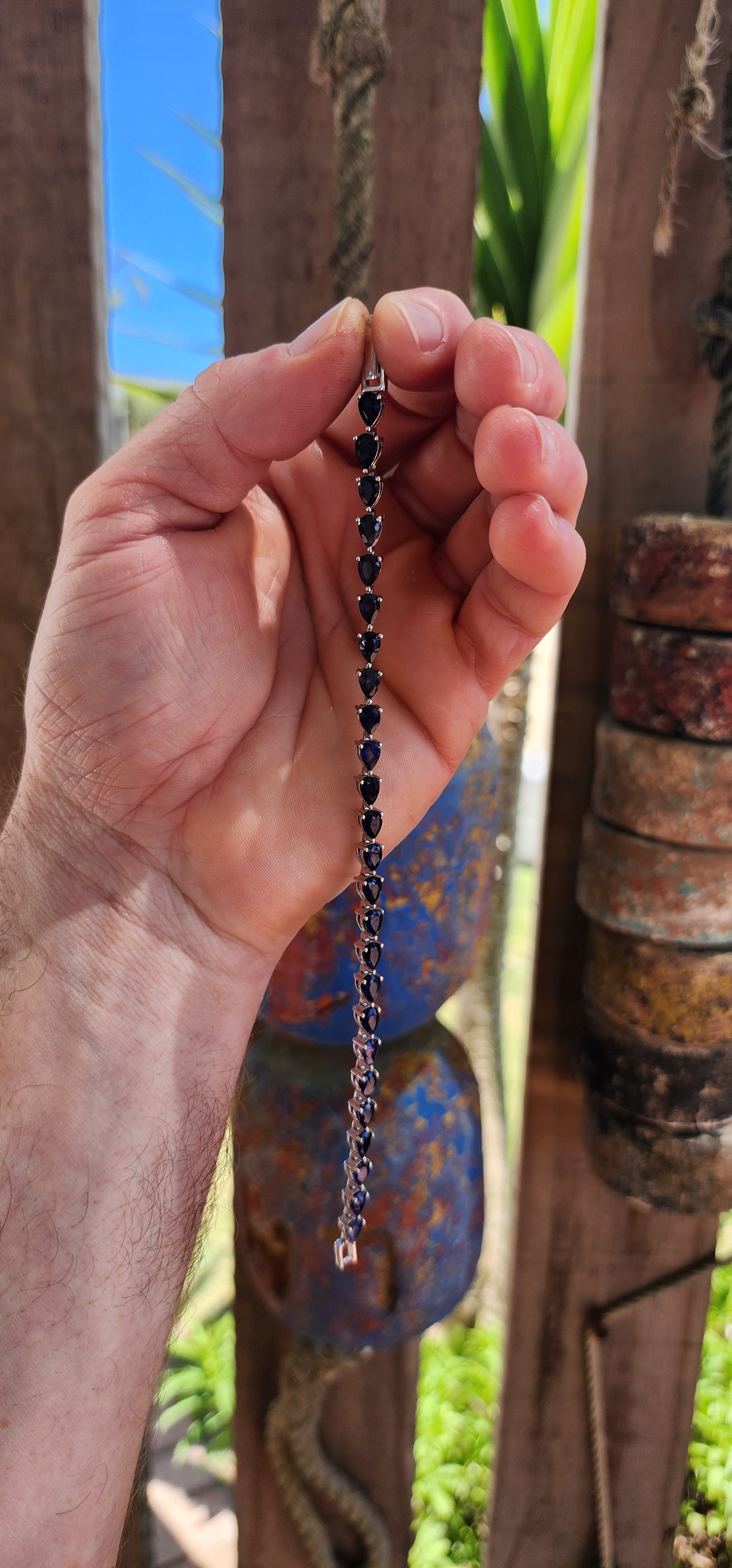Breathtakingly beautiful sterling silver tennis bracelet, shimmering with 25 pear-cut deep-blue sapphires.