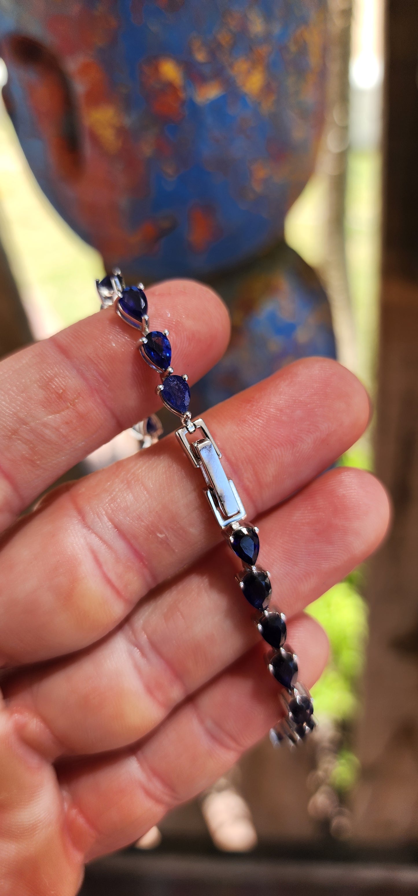 Breathtakingly beautiful sterling silver tennis bracelet, shimmering with 25 pear-cut deep-blue sapphires.