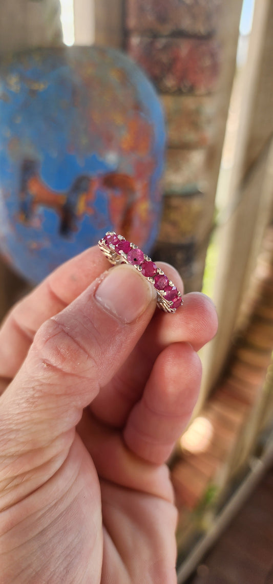 This sterling silver full eternity ring is a true showstopper—crafted with precision and designed to dazzle from every angle. A continuous circle of rich, round-cut rubies is prong-set all the way around.