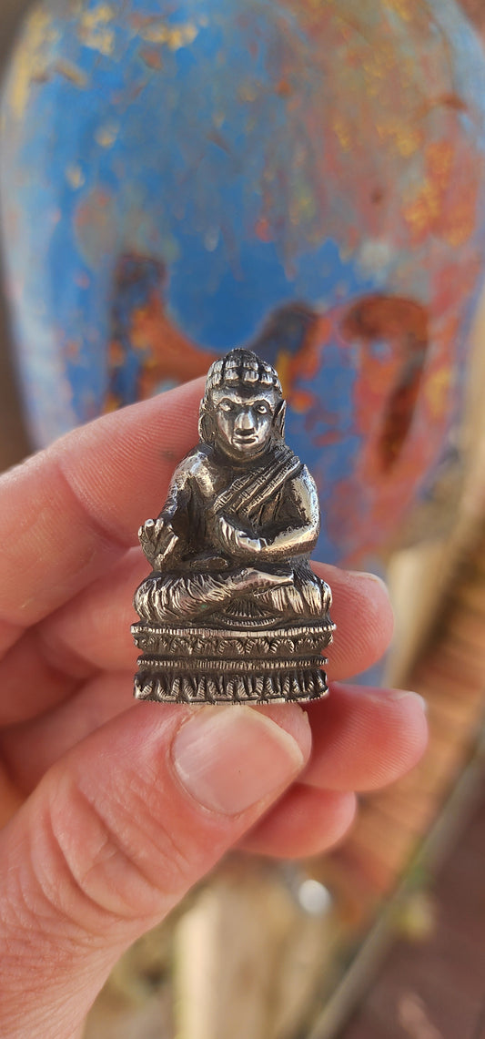 An impressive and wonderfully weighty antique miniature traveling Buddha, finely cast in solid sterling silver.