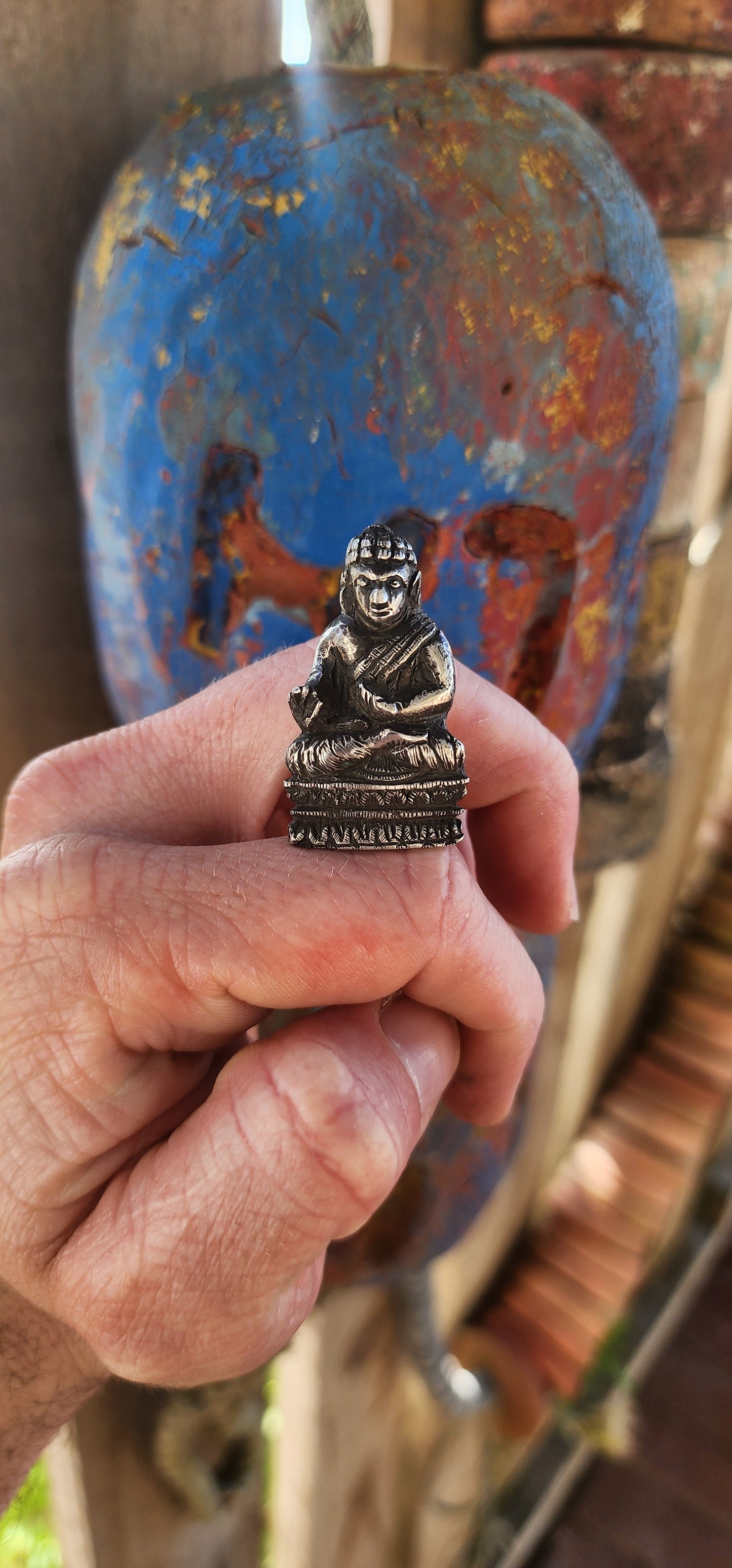 An impressive and wonderfully weighty antique miniature traveling Buddha, finely cast in solid sterling silver.