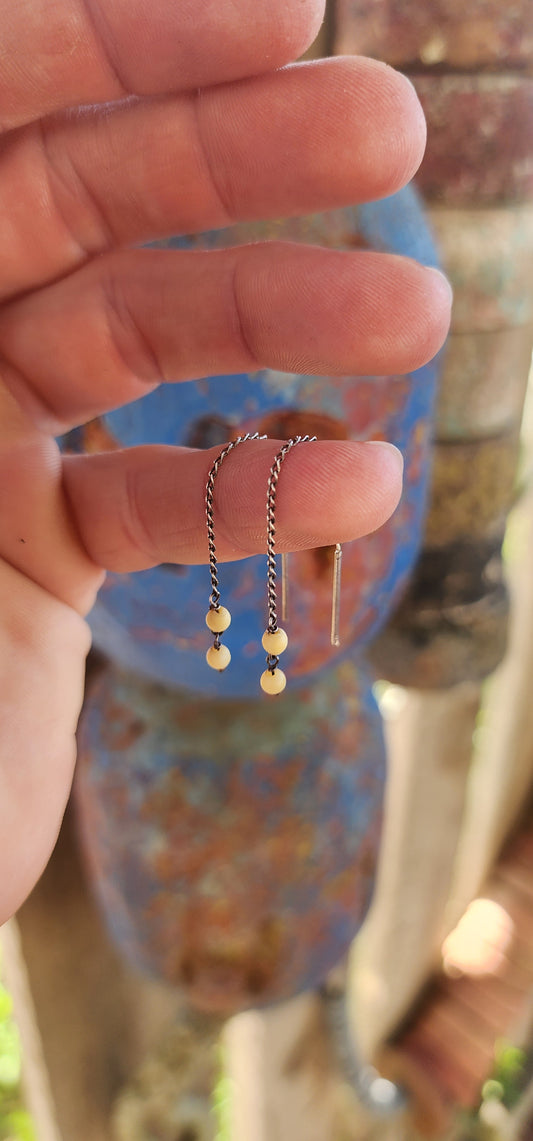 This playful pair of vintage sterling silver threader earrings offers a beautifully balanced mix of sleek metal and warm organic charm.