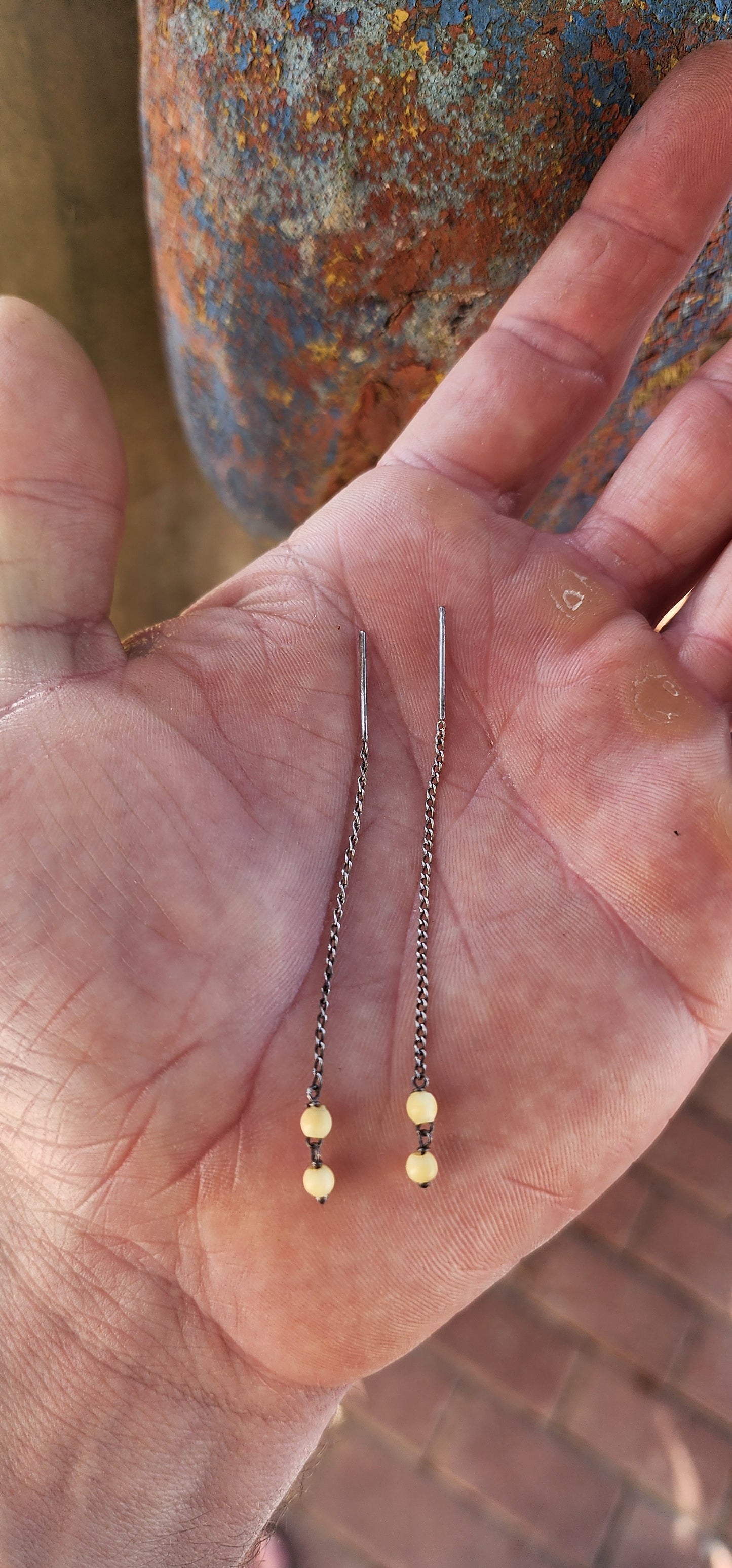 This playful pair of vintage sterling silver threader earrings offers a beautifully balanced mix of sleek metal and warm organic charm.