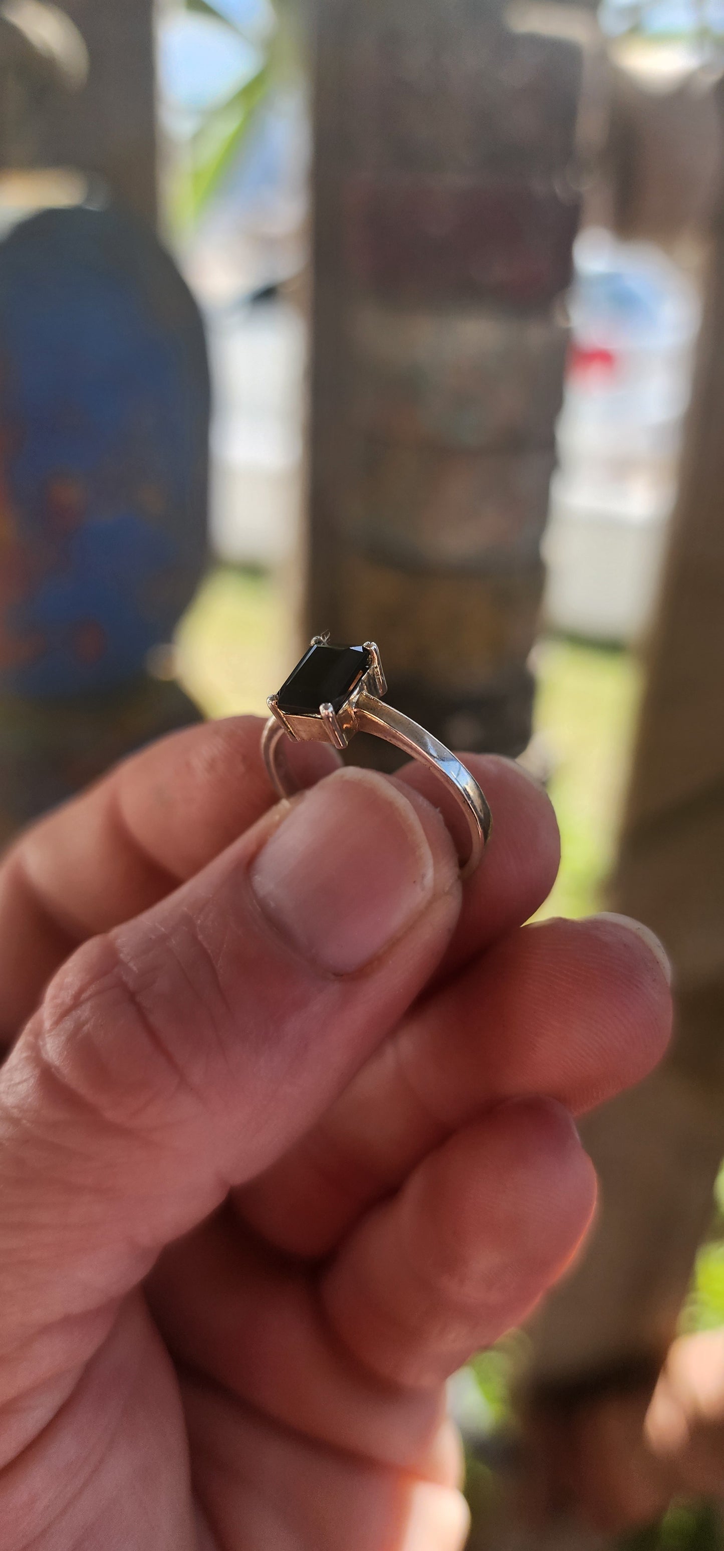 This striking sterling silver solitaire ring showcases a bold emerald-cut black onyx, elevated proudly in a sleek prong-set basket.