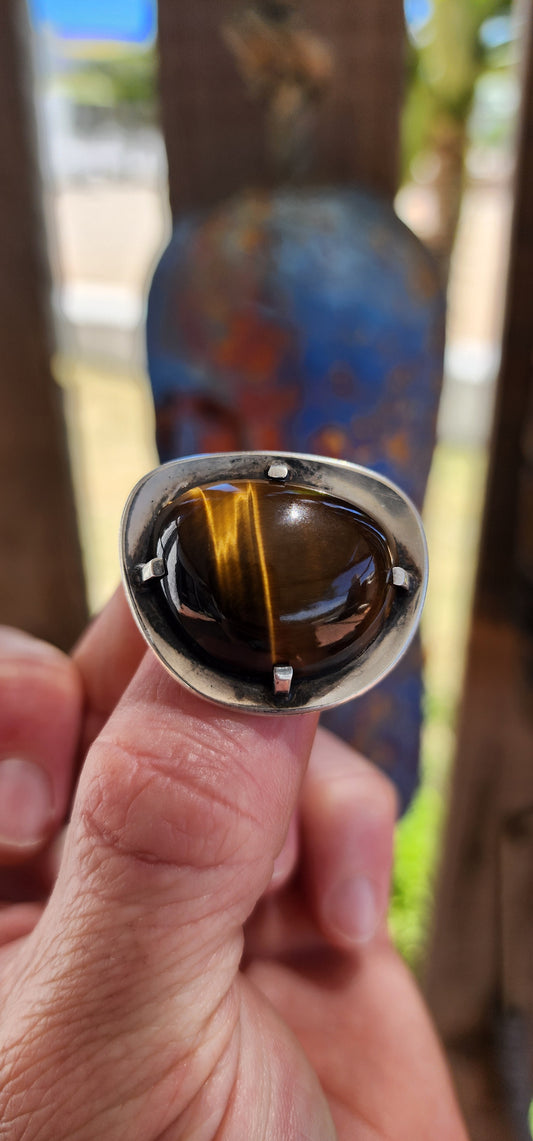 A bold and beautifully crafted vintage modernist brooch dating to the circa 1970s, this striking piece showcases a generously sized, high-domed Tiger’s Eye cabochon set in hand-crafted sterling silver.