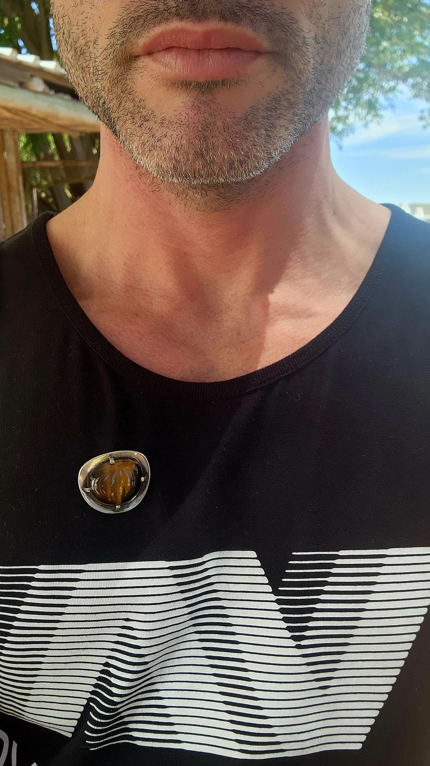 A bold and beautifully crafted vintage modernist brooch dating to the circa 1970s, this striking piece showcases a generously sized, high-domed Tiger’s Eye cabochon set in hand-crafted sterling silver.