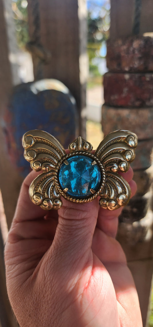 This large-sized vintage novelty brooch is crafted in the shapely silhouette of an Art Deco butterfly, complete with exaggerated scrolling wings, raised bead detailing, and that old-world theatrical flair the 1920s did best.