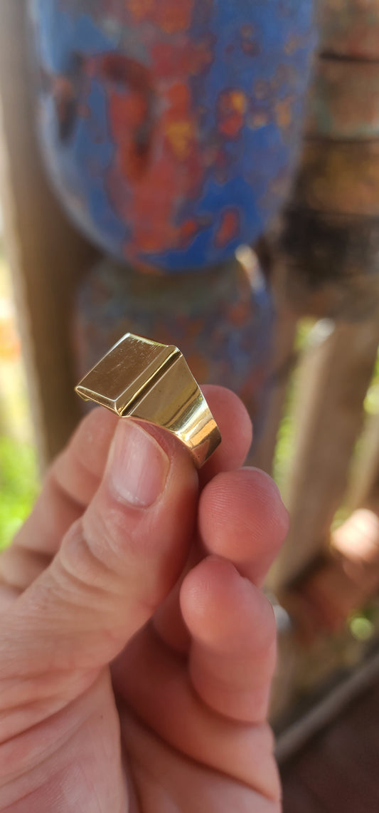 This striking golden brass signet ring is the definition of clean, confident design — a piece that feels equally at home on a modern minimalist or a vintage-loving treasure hunter.