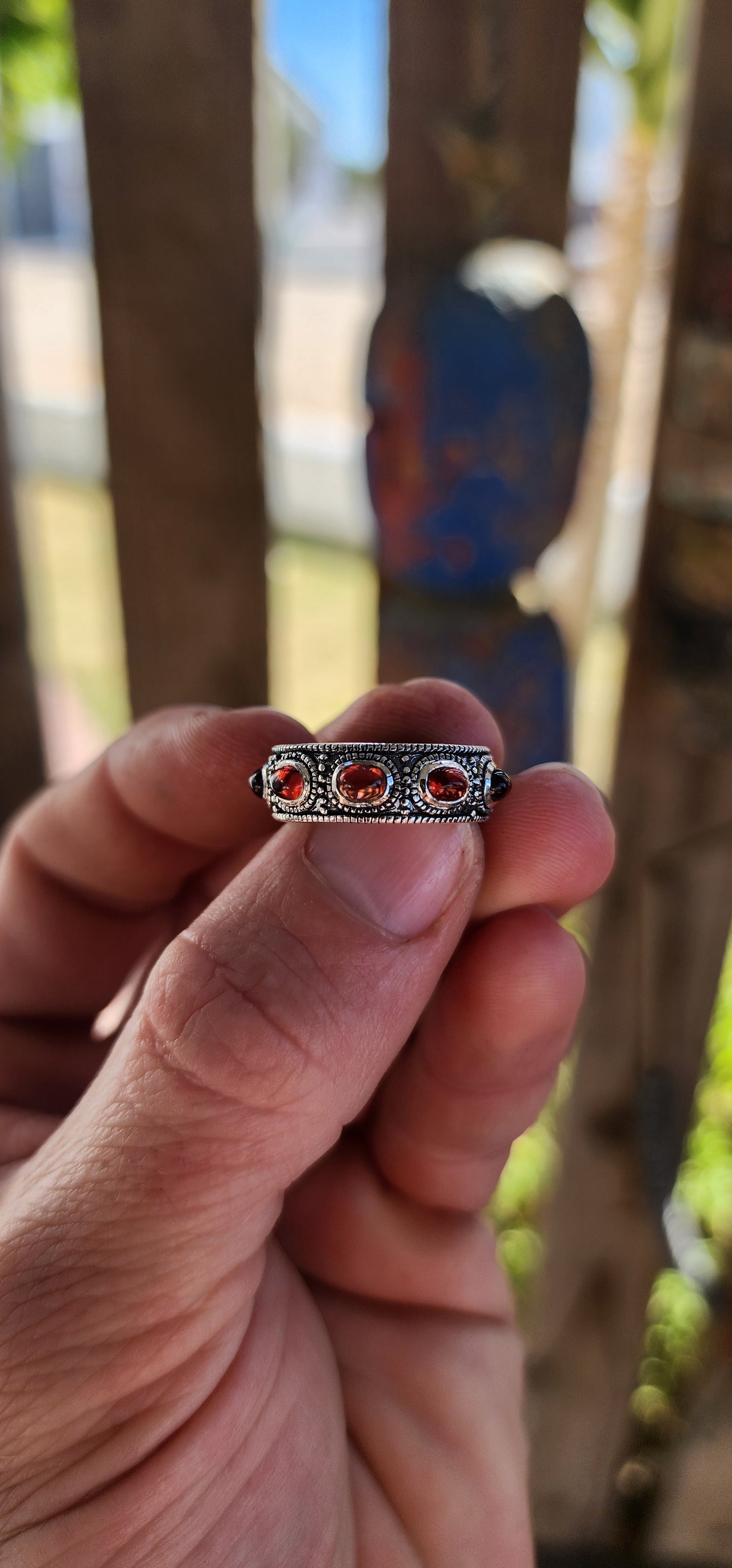 This fabulous unisex sterling silver full eternity ring is pure boho royalty — a band of endless fire wrapped around your finger. Set all the way around the entire circumference are 9 rich oval garnet cabochons.