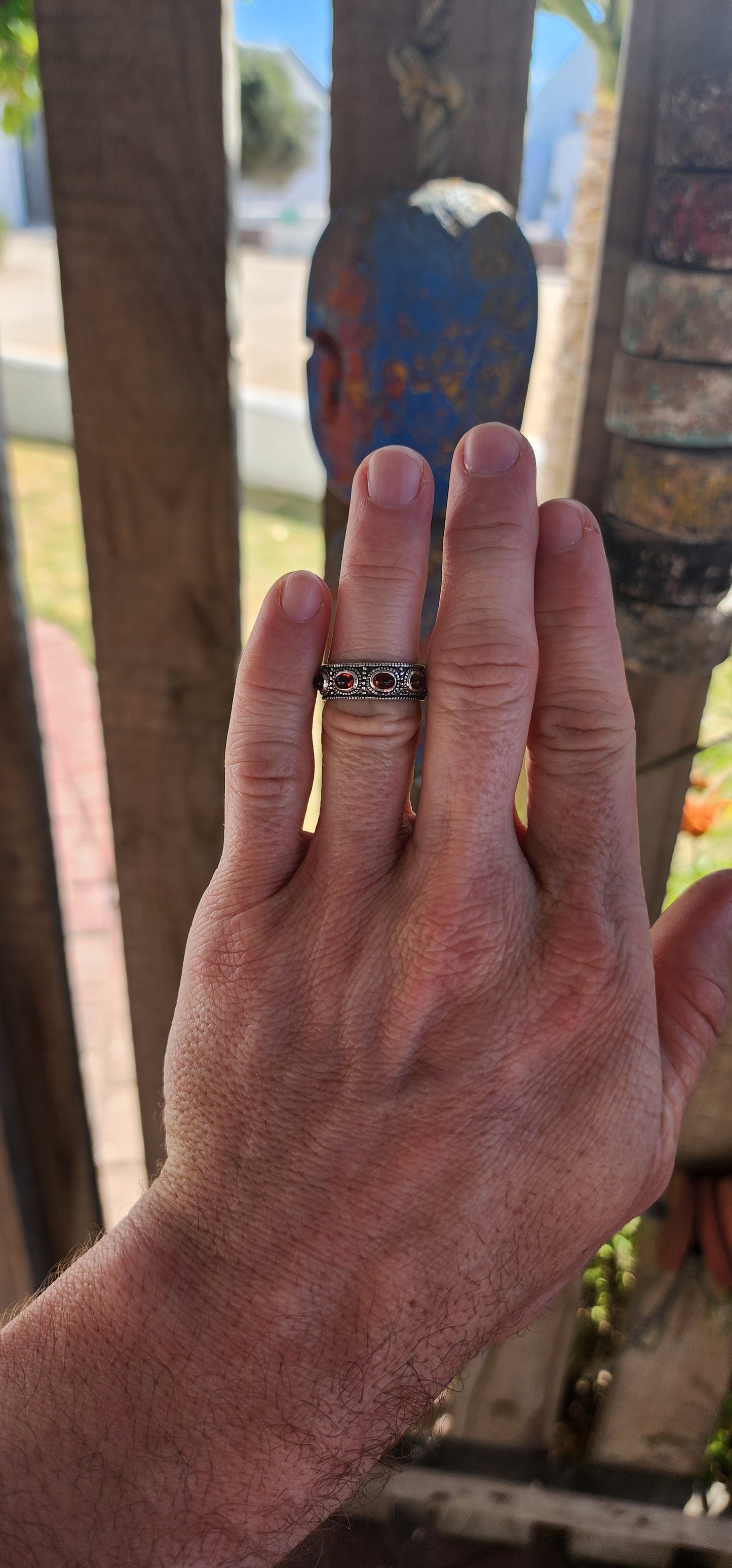 This fabulous unisex sterling silver full eternity ring is pure boho royalty — a band of endless fire wrapped around your finger. Set all the way around the entire circumference are 9 rich oval garnet cabochons.
