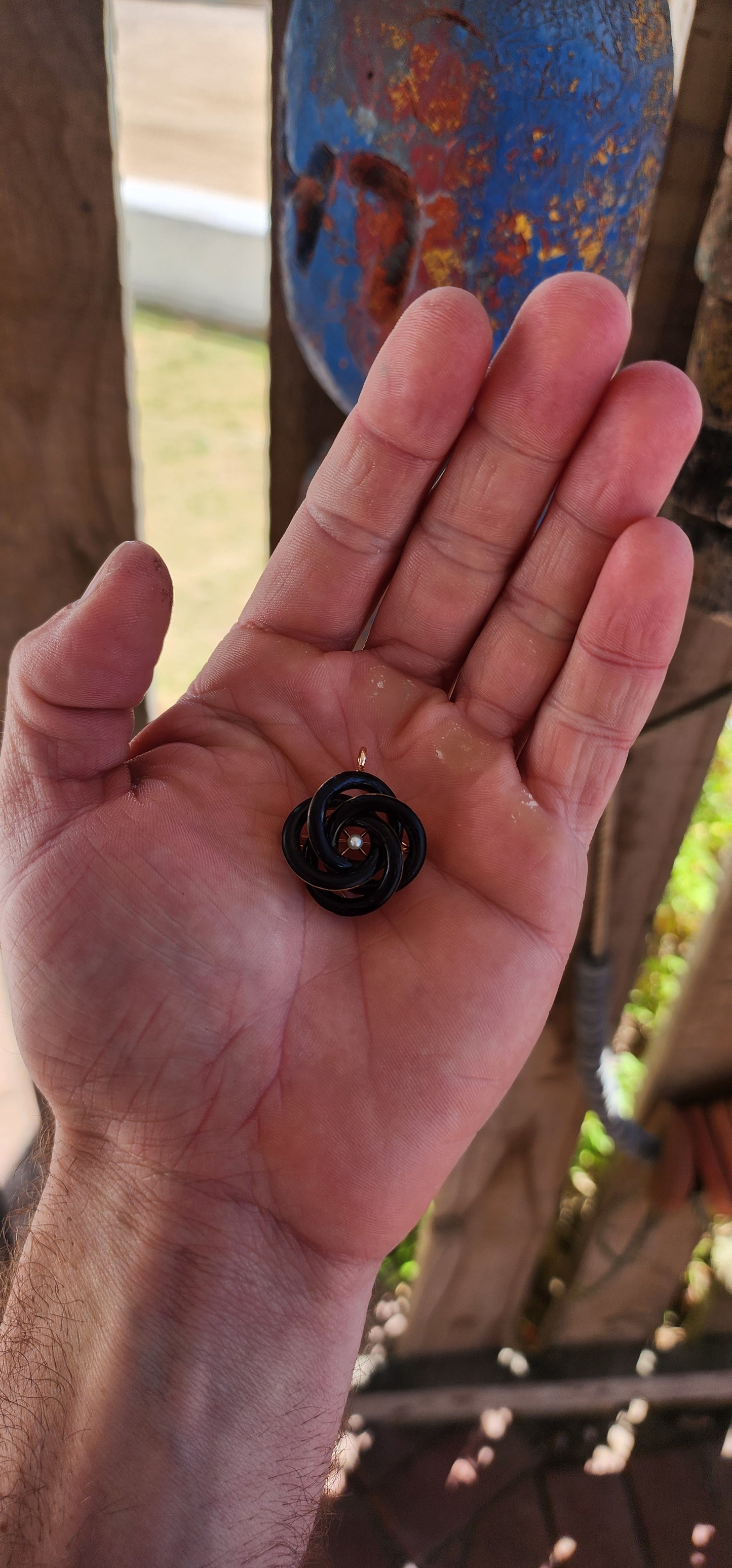 An exceptionally rare Antique Victorian mourning brooch / pendant, crafted in 10ct rosy gold, formed as a deeply symbolic eternity love knot, ebonised to a dramatic inky black enamel and centred with a single, luminous marine cultured pearl.