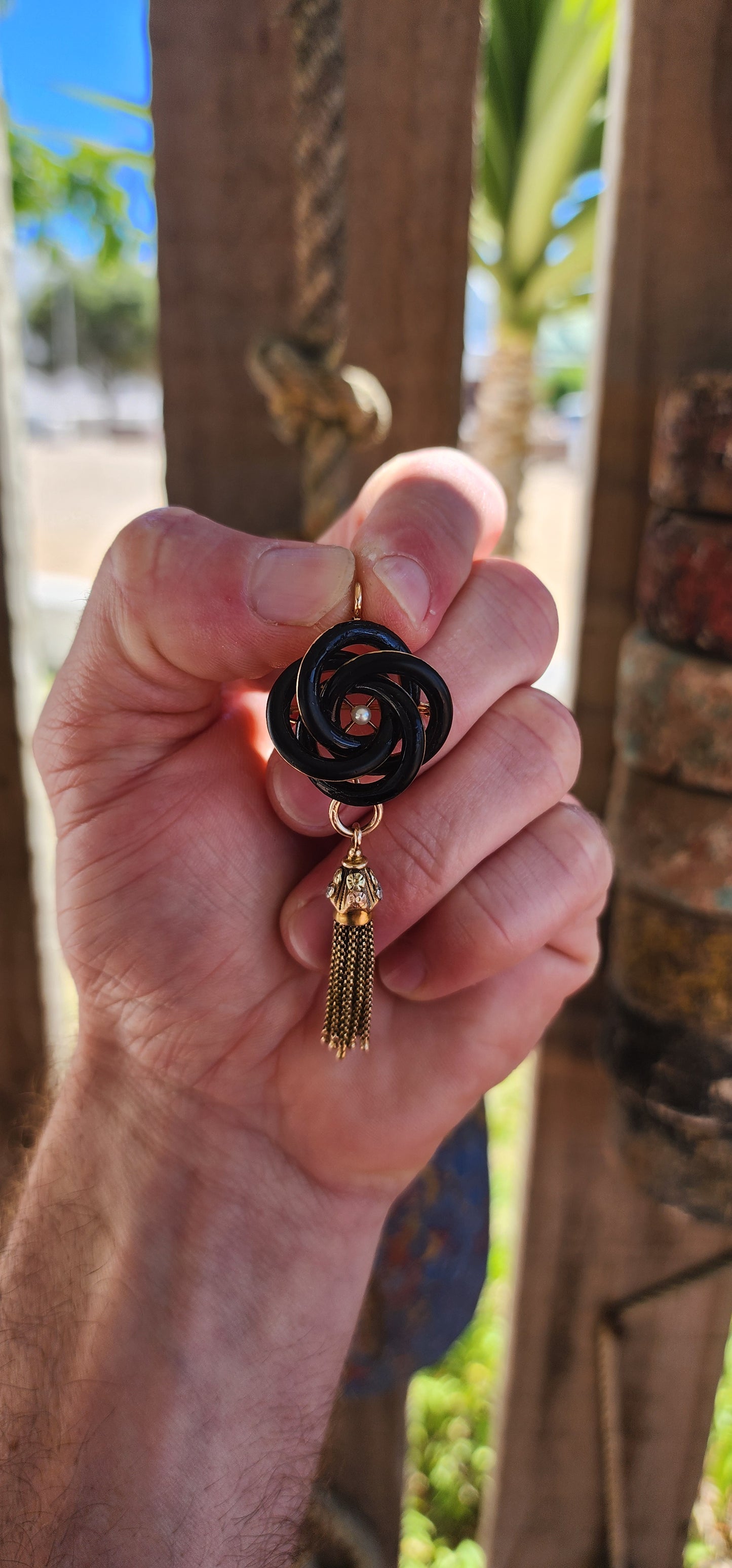 An exceptionally rare Antique Victorian mourning brooch / pendant, crafted in 10ct rosy gold, formed as a deeply symbolic eternity love knot, ebonised to a dramatic inky black enamel and centred with a single, luminous marine cultured pearl.