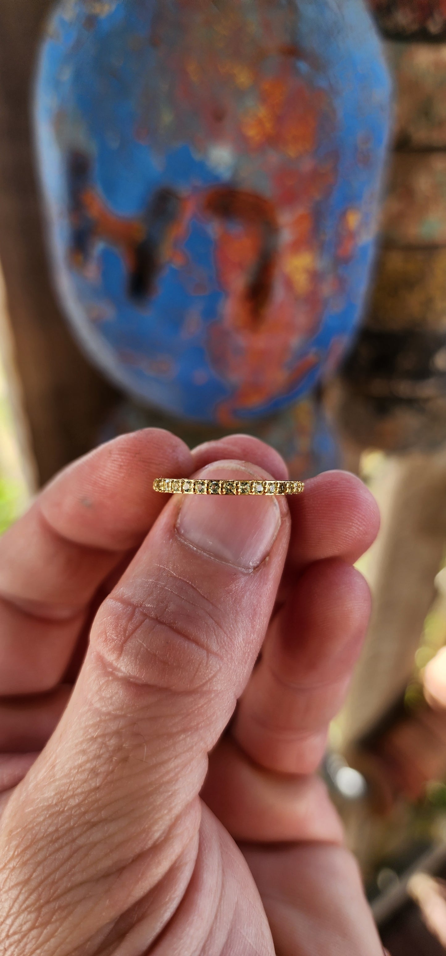 A sterling silver full eternity stacking ring, luxuriously plated in 18ct yellow gold and adorned with a continuous circle of sparkling Green Peridots.