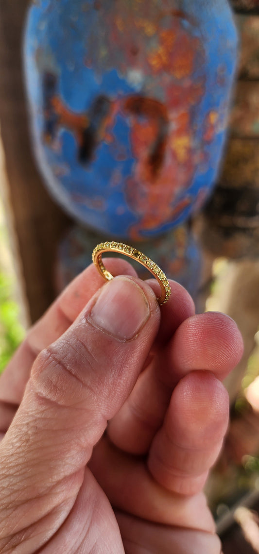A sterling silver full eternity stacking ring, luxuriously plated in 18ct yellow gold and adorned with a continuous circle of sparkling Green Peridots.