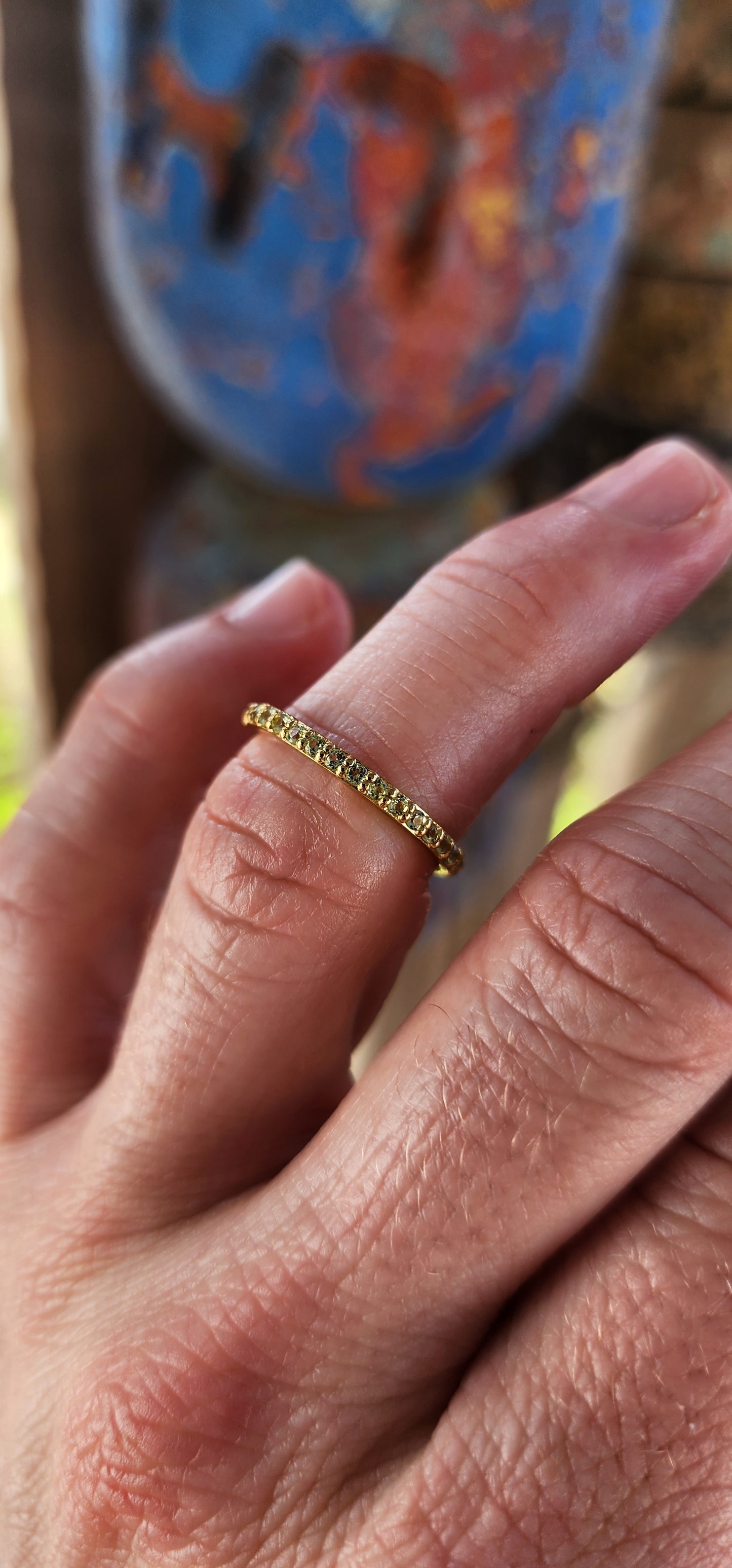 A sterling silver full eternity stacking ring, luxuriously plated in 18ct yellow gold and adorned with a continuous circle of sparkling Green Peridots.