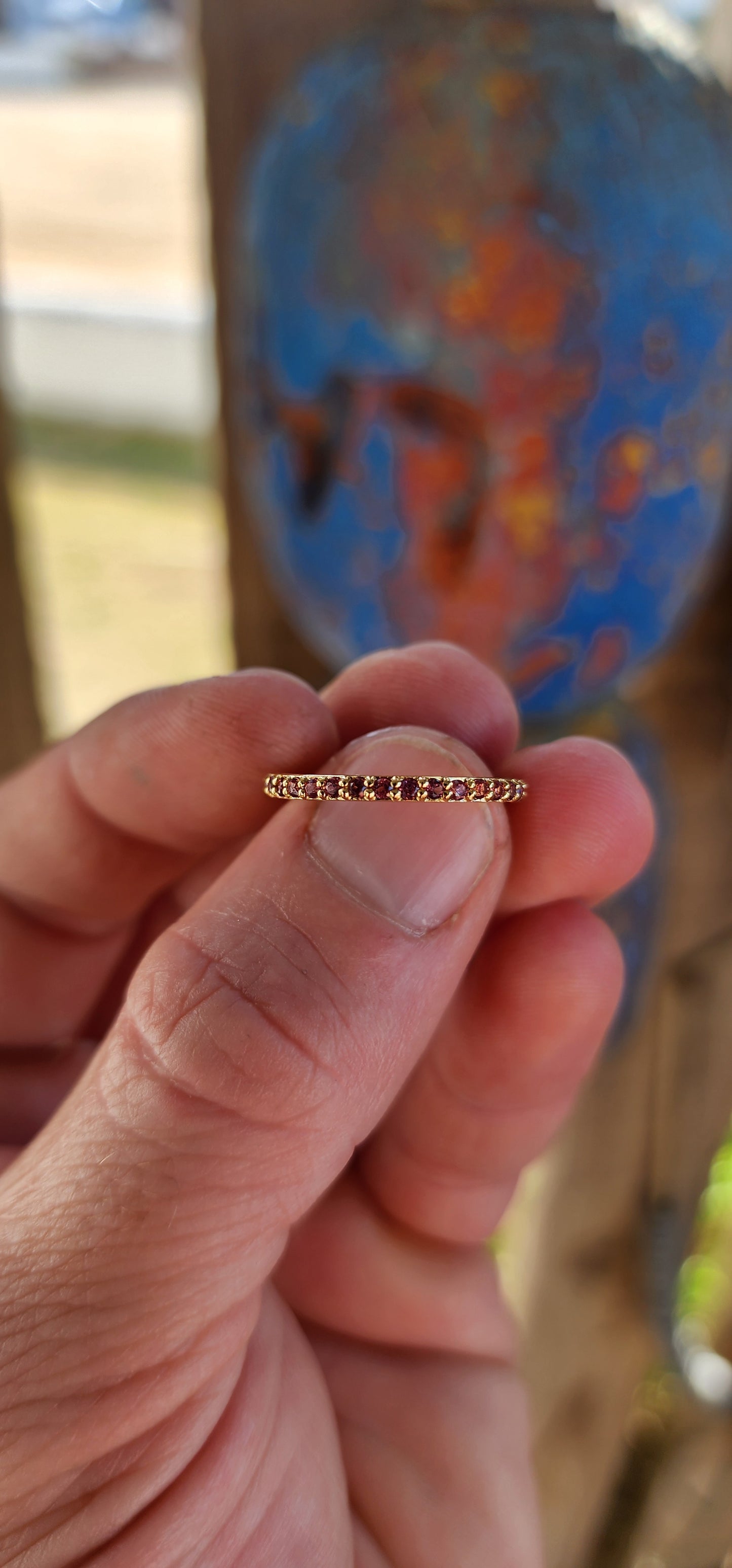A sterling silver full eternity stacking ring, luxuriously plated in 18ct yellow gold and adorned with a continuous circle of sparkling Purple/Red Rhodolite Garnets.