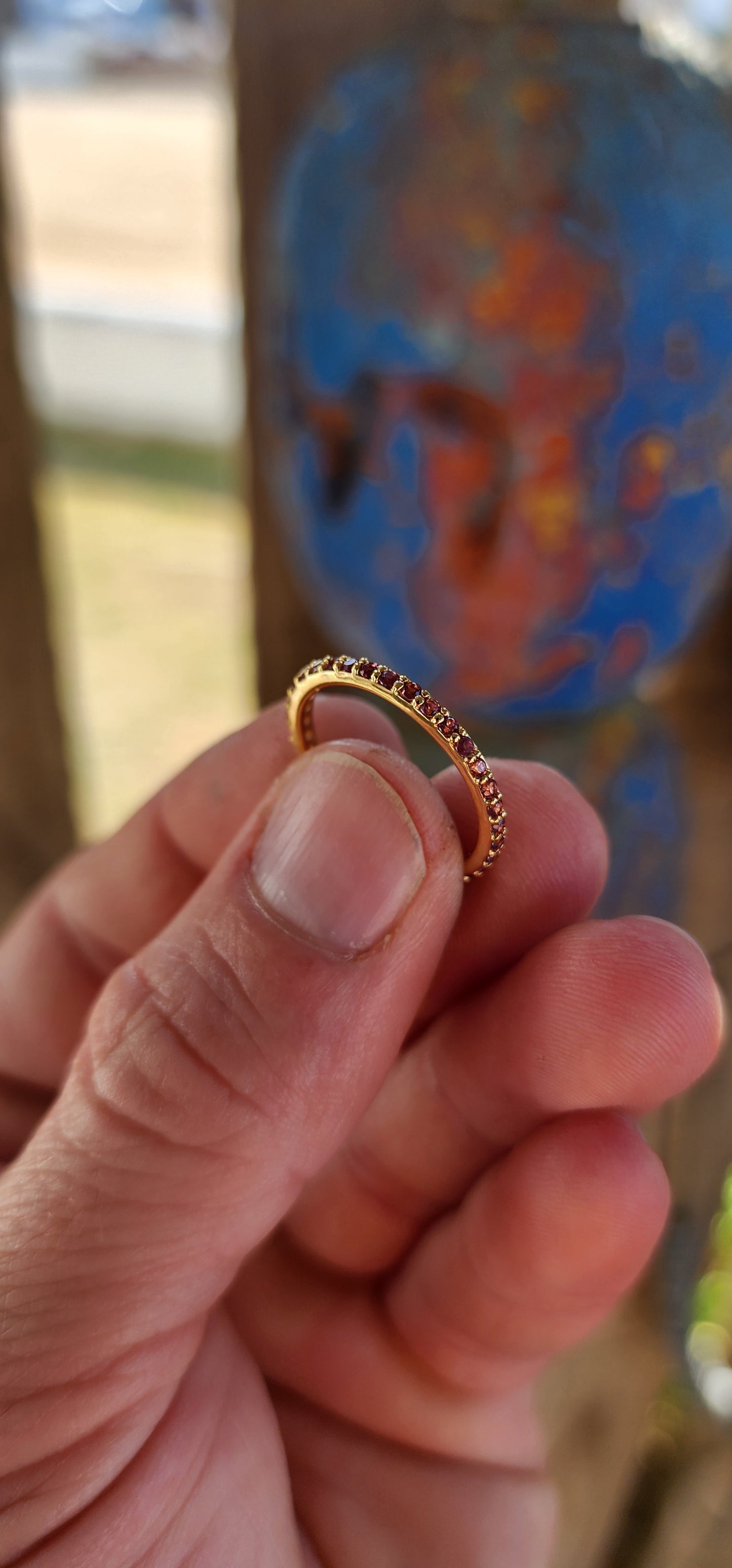 A sterling silver full eternity stacking ring, luxuriously plated in 18ct yellow gold and adorned with a continuous circle of sparkling Purple/Red Rhodolite Garnets.