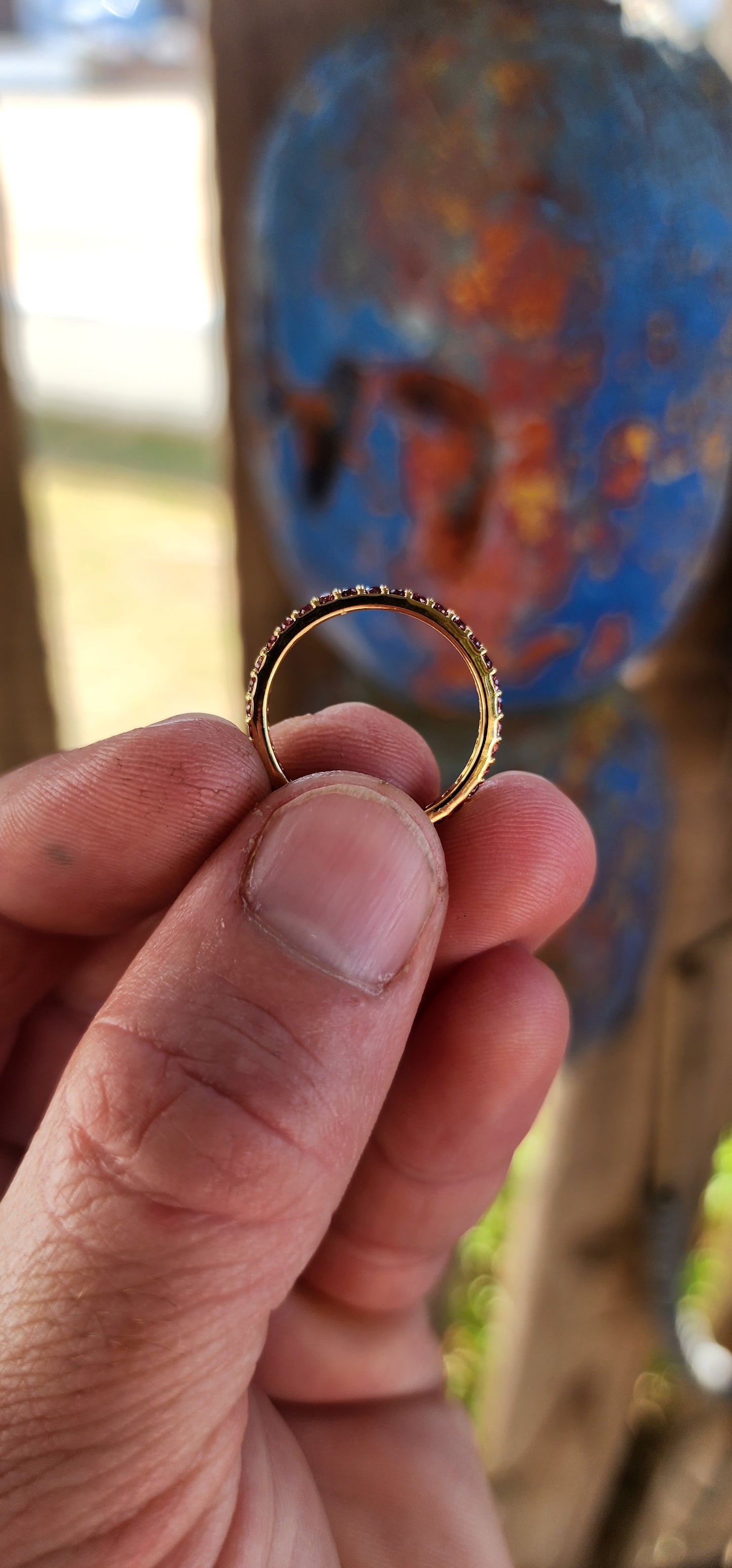 A sterling silver full eternity stacking ring, luxuriously plated in 18ct yellow gold and adorned with a continuous circle of sparkling Purple/Red Rhodolite Garnets.