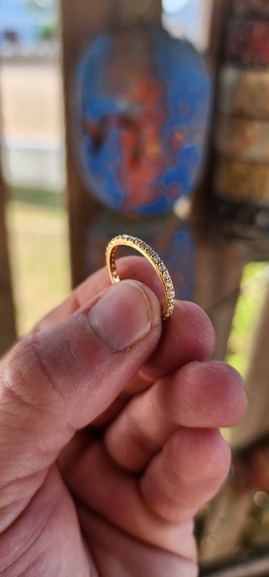 A sterling silver full eternity stacking ring, luxuriously plated in 18ct yellow gold and adorned with a continuous circle of sparkling White Zircons.