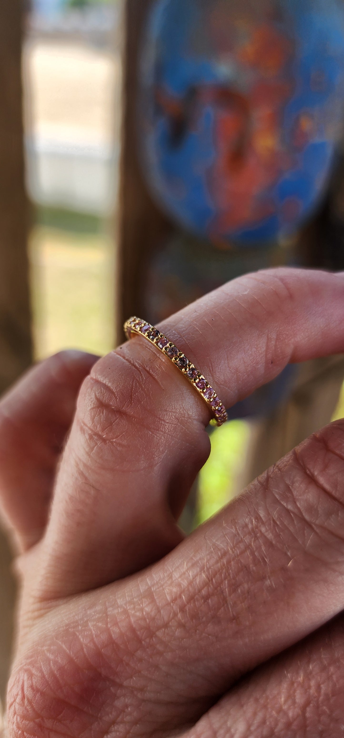 A sterling silver full eternity stacking ring, luxuriously plated in 18ct yellow gold and adorned with a continuous circle of sparkling Pink Sapphires.