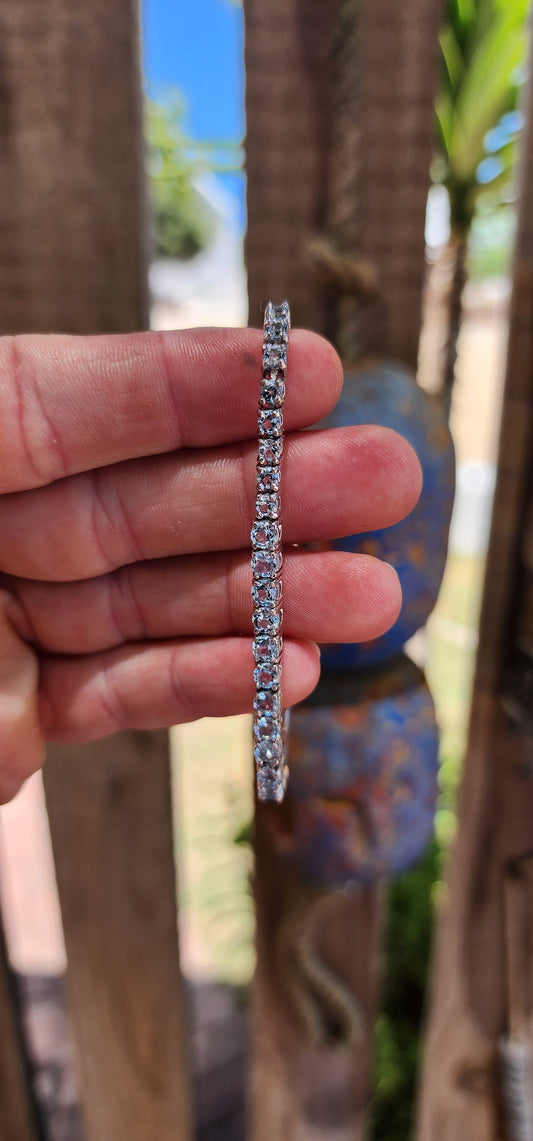 Effortlessly refined with a fresh, luminous glow, this classic tennis bracelet is crafted in polished sterling silver and set with a continuous line of sparkling sky blue topaz gemstones.