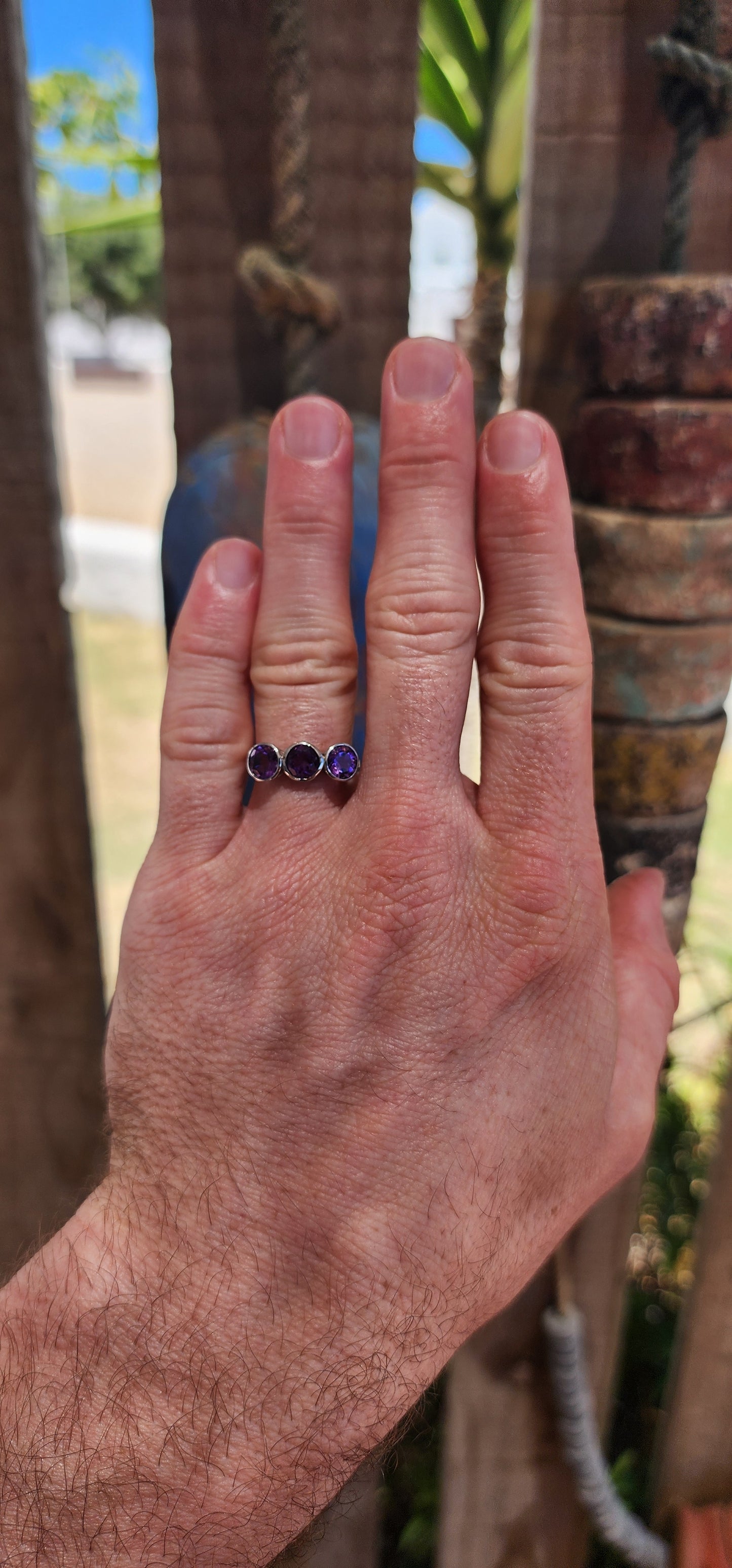 This sterling silver trilogy ring is a dreamy celebration of amethyst magic, set with three round faceted amethyst gemstones that glow in juicy shades of violet, plum and royal purple.