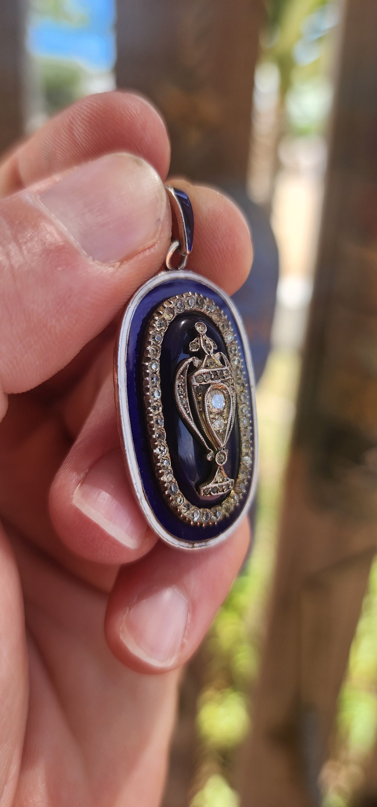 An exceptionally rare early 19th-century Georgian mourning pendant, crafted in sterling silver and lavishly decorated with royal blue and white enamel, glittering paste stones, and natural diamonds.