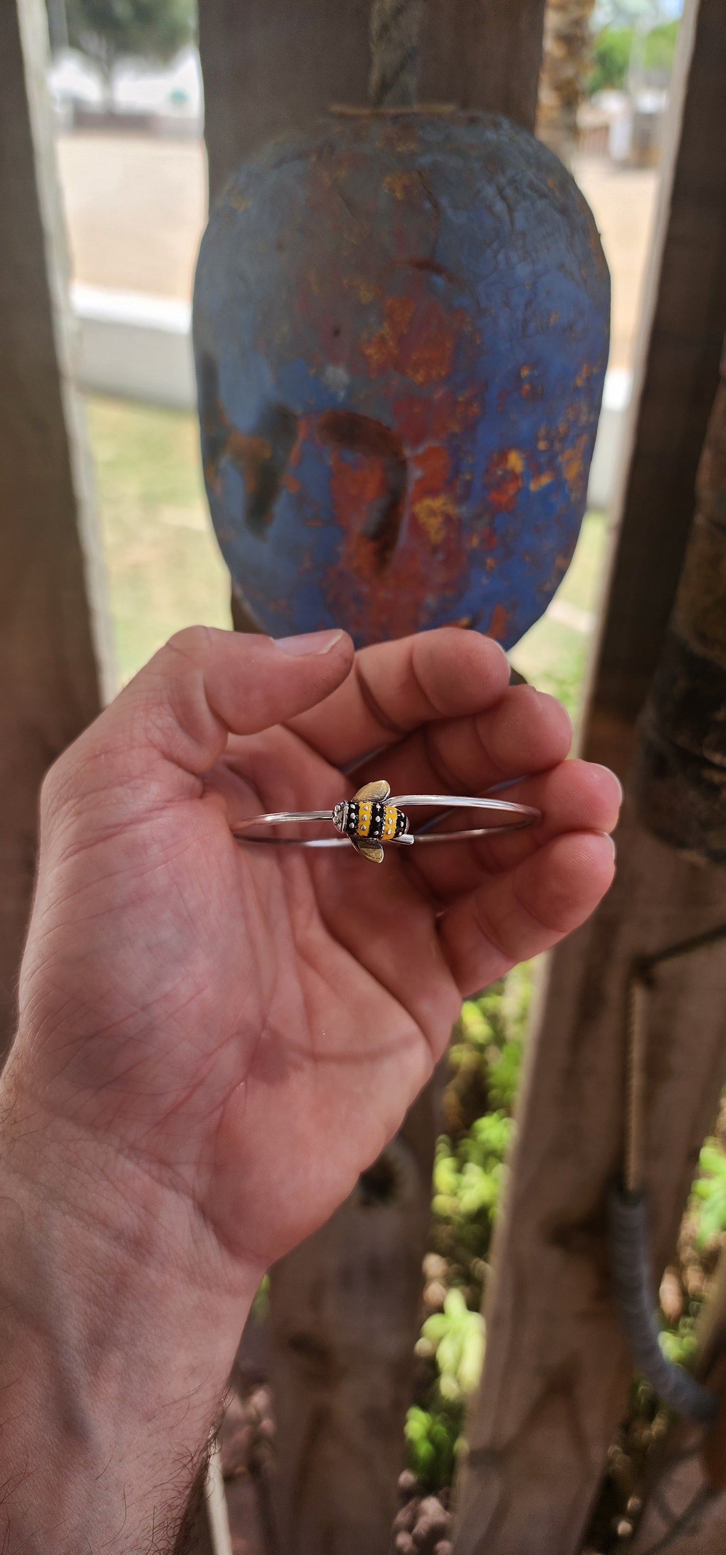 A charming designer sterling silver clip bangle by Daisy London, featuring the sweetest little enamelled bee perched at the centre.