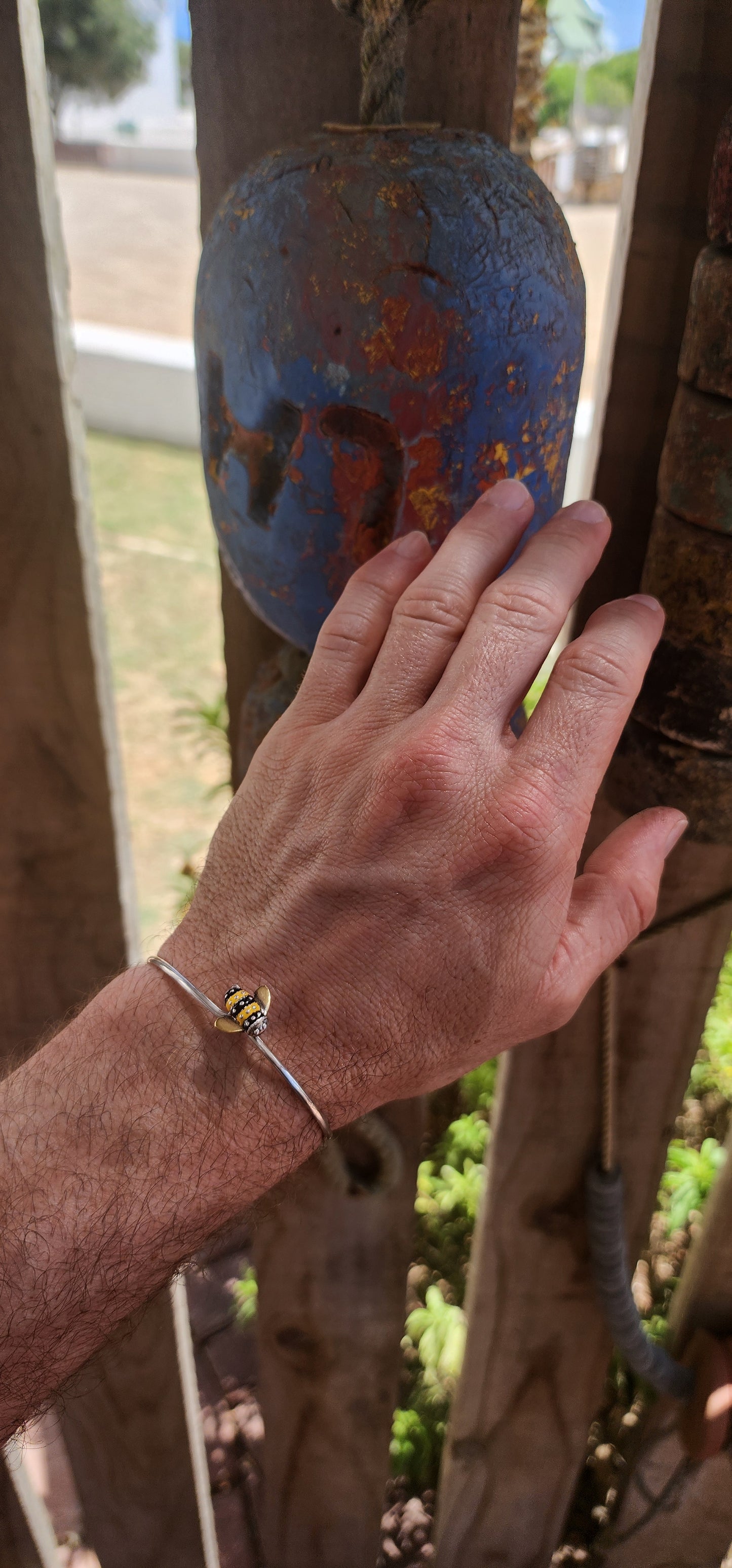 A charming designer sterling silver clip bangle by Daisy London, featuring the sweetest little enamelled bee perched at the centre.