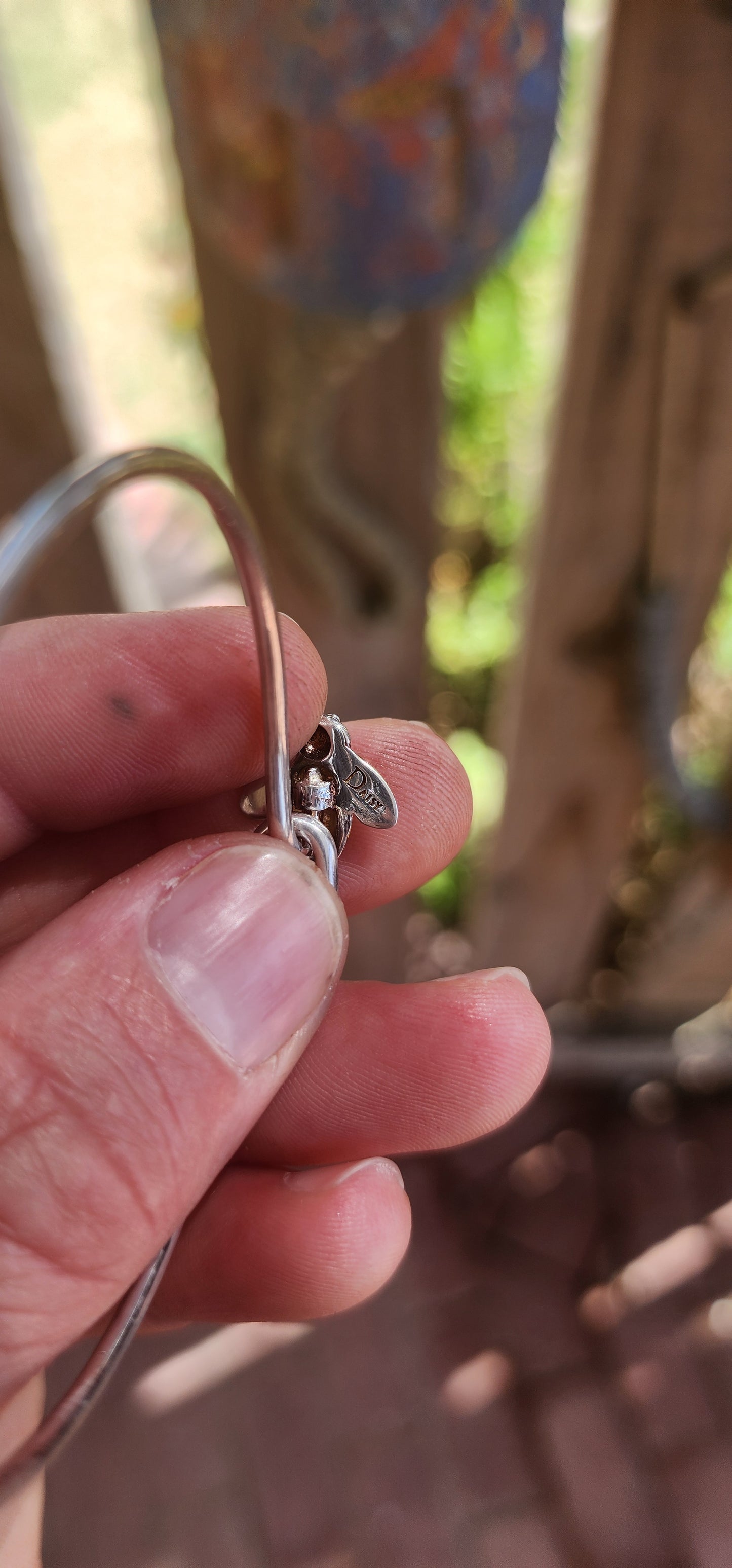 A charming designer sterling silver clip bangle by Daisy London, featuring the sweetest little enamelled bee perched at the centre.