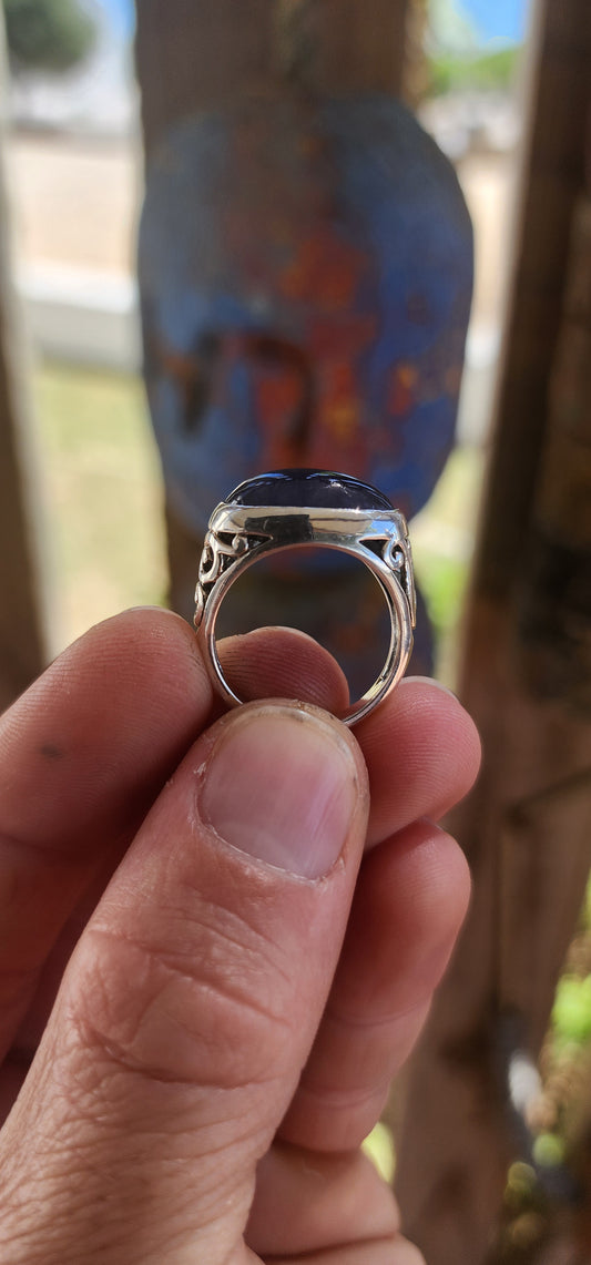 A striking unisex sterling silver dress ring showcasing a generously sized oval blue sapphire cabochon as its commanding centrepiece