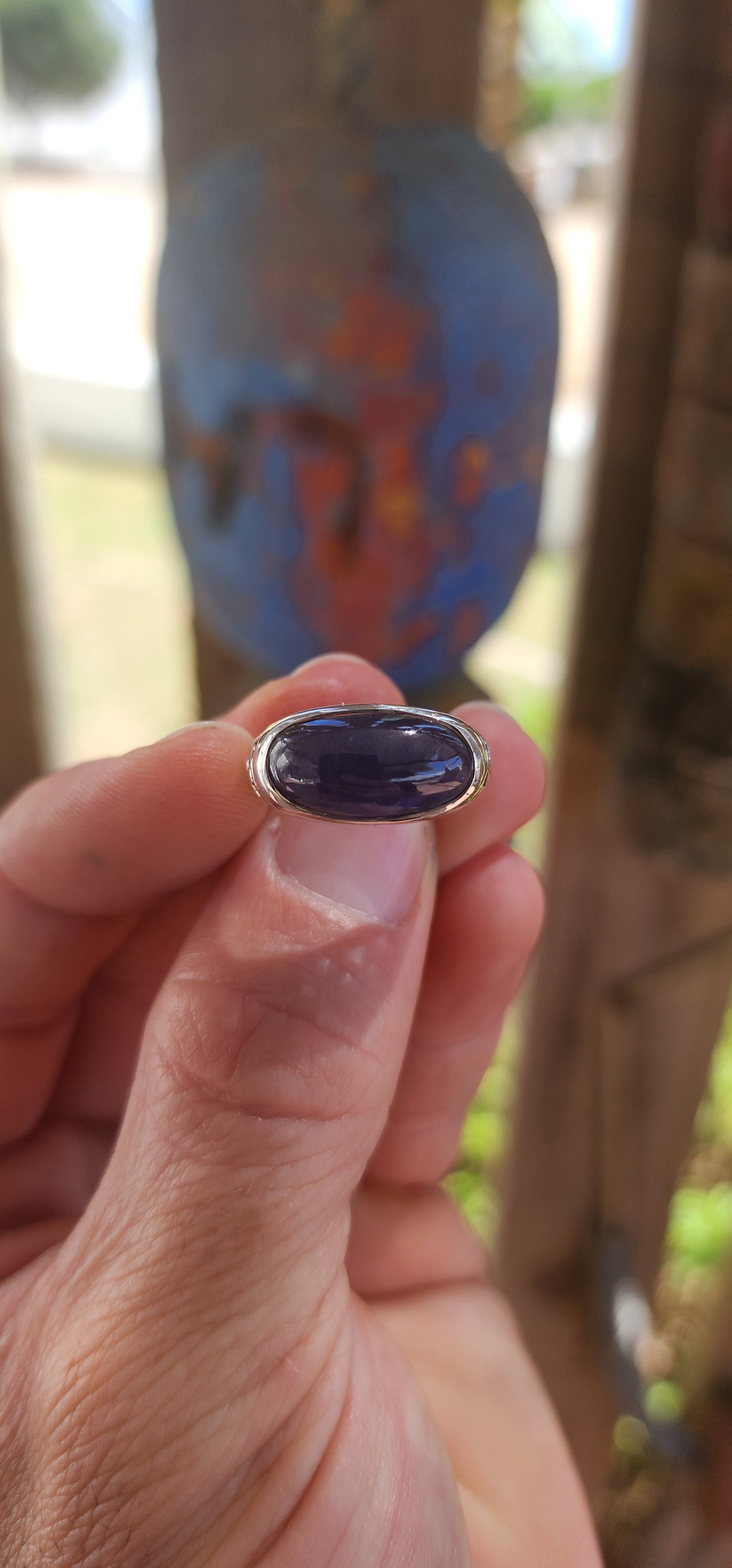 A striking unisex sterling silver dress ring showcasing a generously sized oval blue sapphire cabochon as its commanding centrepiece
