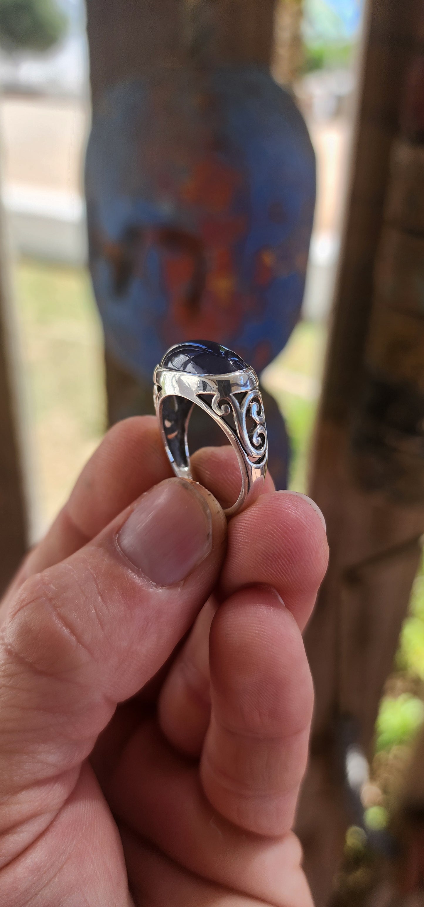 A striking unisex sterling silver dress ring showcasing a generously sized oval blue sapphire cabochon as its commanding centrepiece