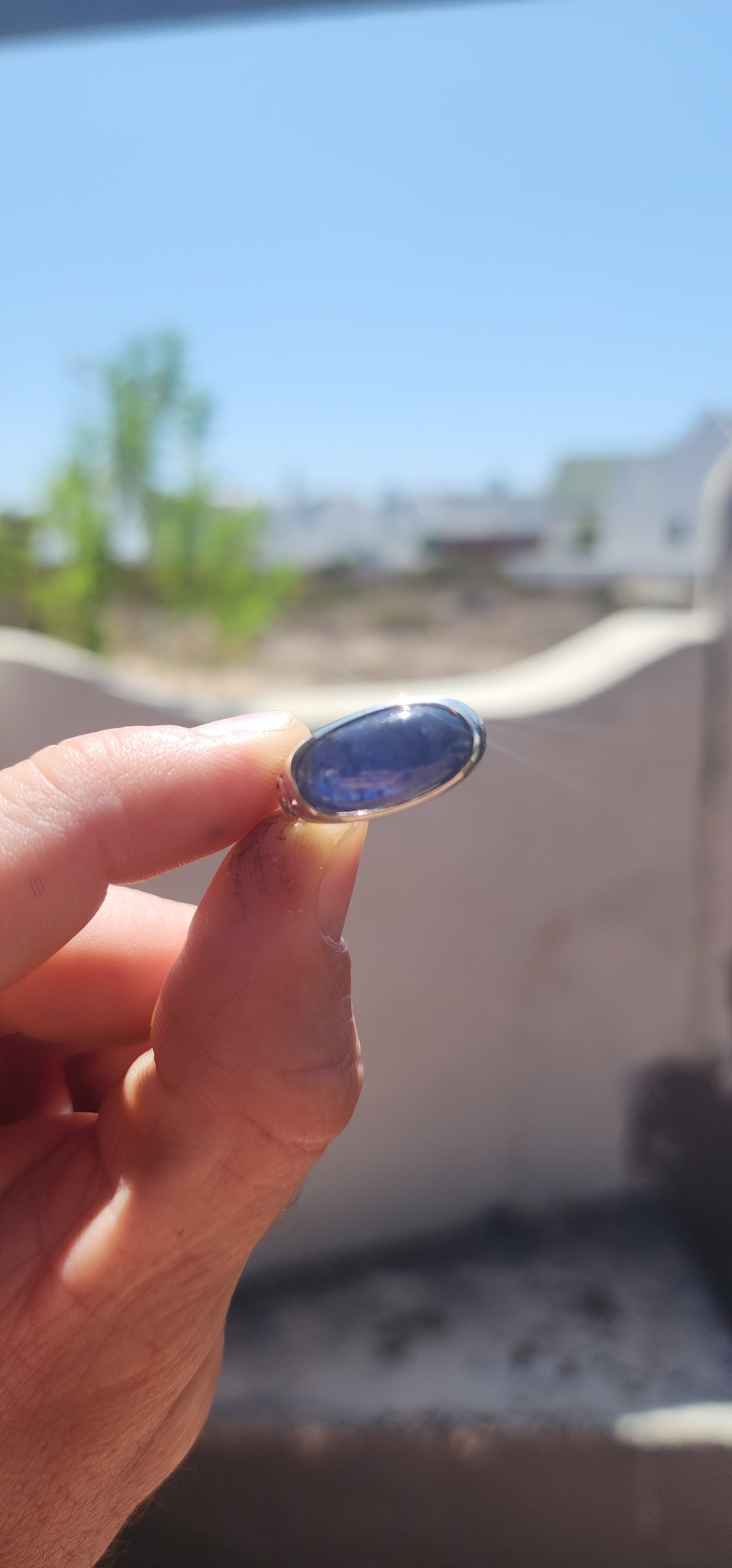 A striking unisex sterling silver dress ring showcasing a generously sized oval blue sapphire cabochon as its commanding centrepiece