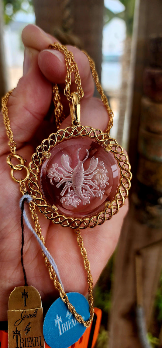 This is an exceptional and ultra-rare survivor from the golden age of American costume jewellery — a 1960s Crown Trifari zodiac “Cancer” pendant, presented here in unworn, original condition with its factory tags still attached. A true time-capsule piece.