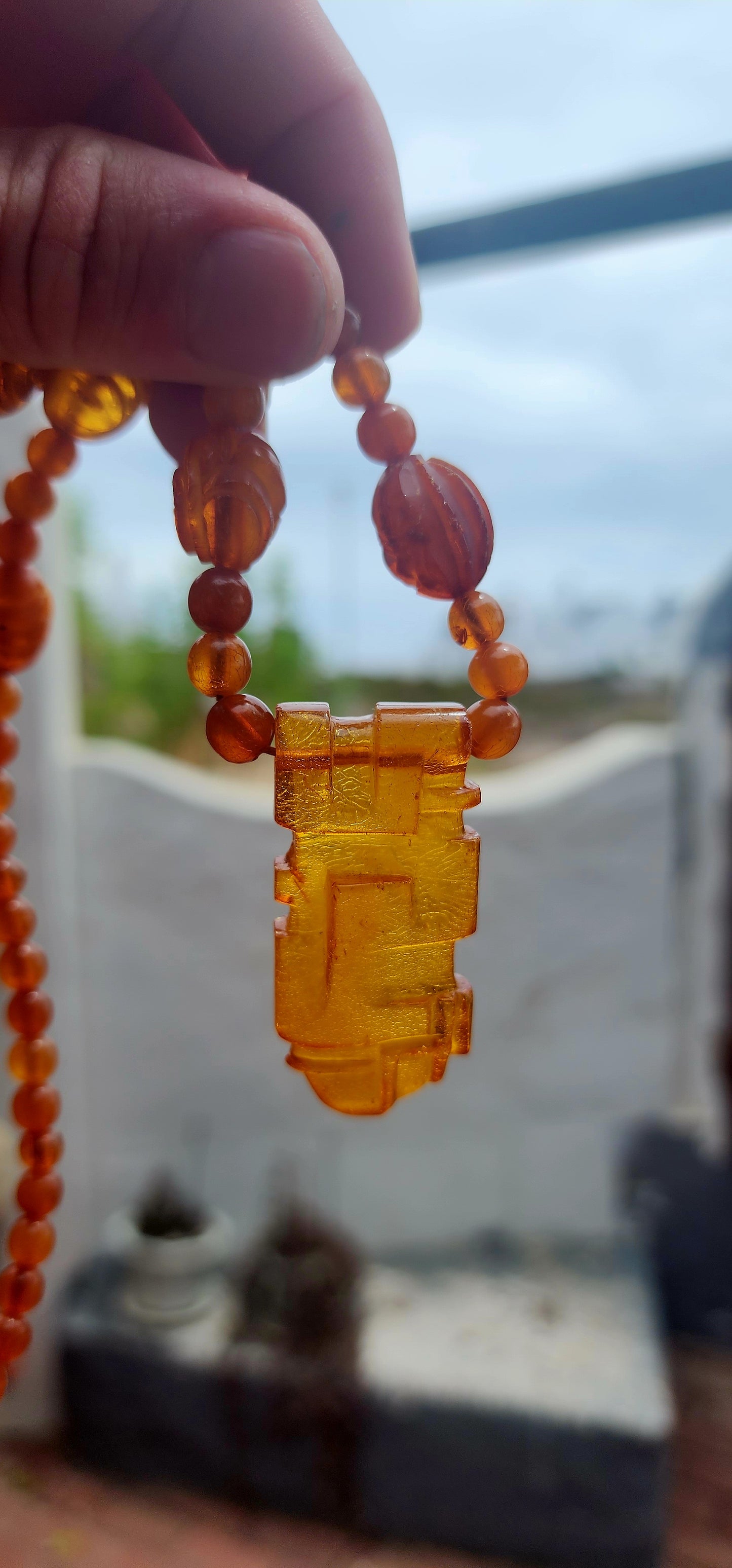 This marvelous Art Deco era (circa 1920s) Baltic amber necklace is crafted in a striking Aztec / Mesoamerican revival style.