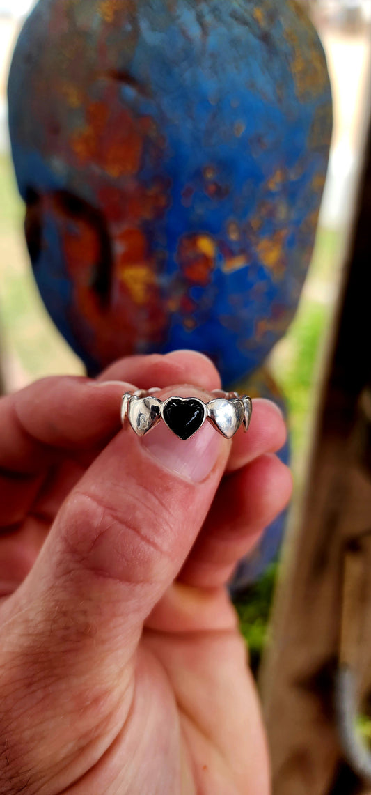 This artisan-made sterling silver ring is a full eternity style band featuring softly domed silver hearts wrapping all the way around the finger.