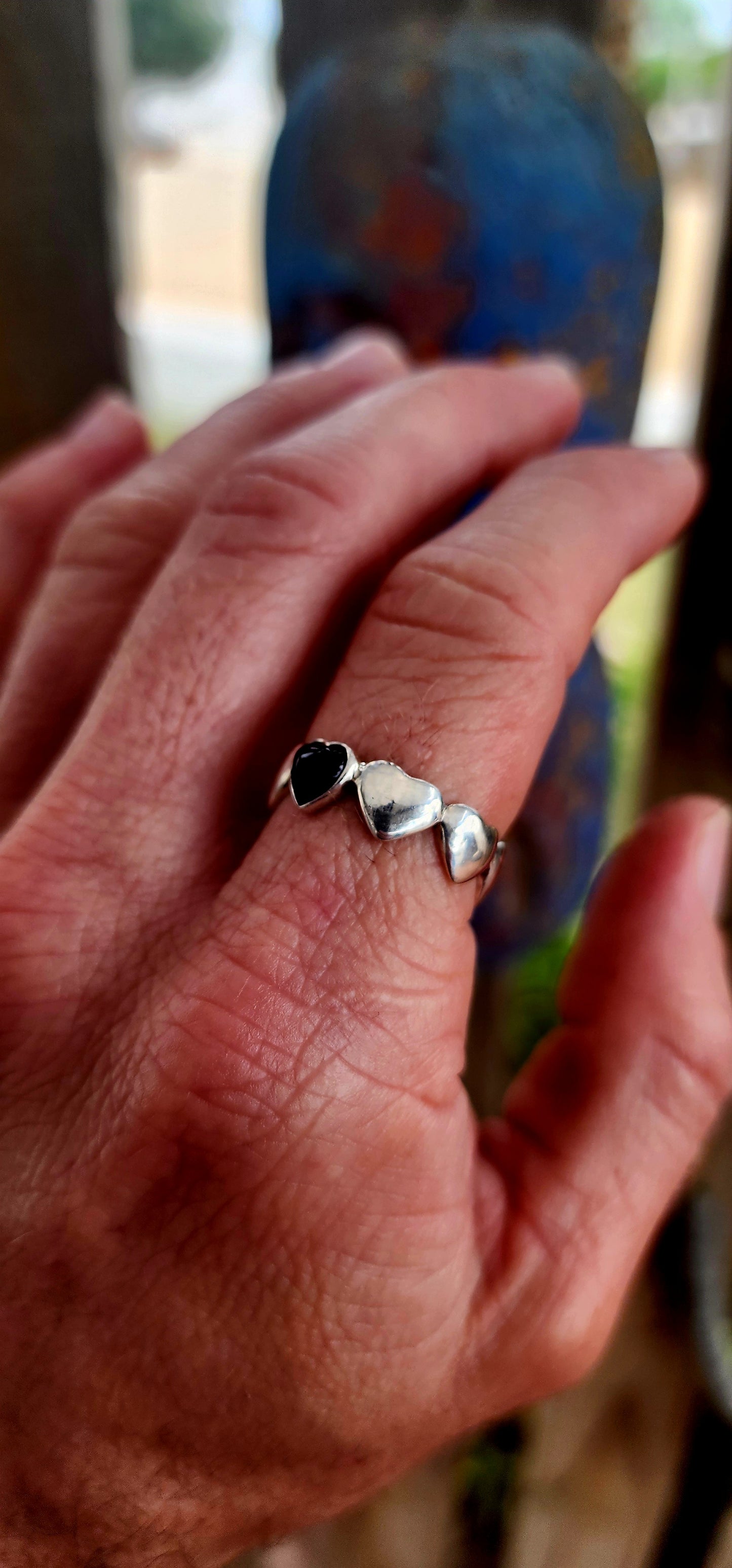 This artisan-made sterling silver ring is a full eternity style band featuring softly domed silver hearts wrapping all the way around the finger.