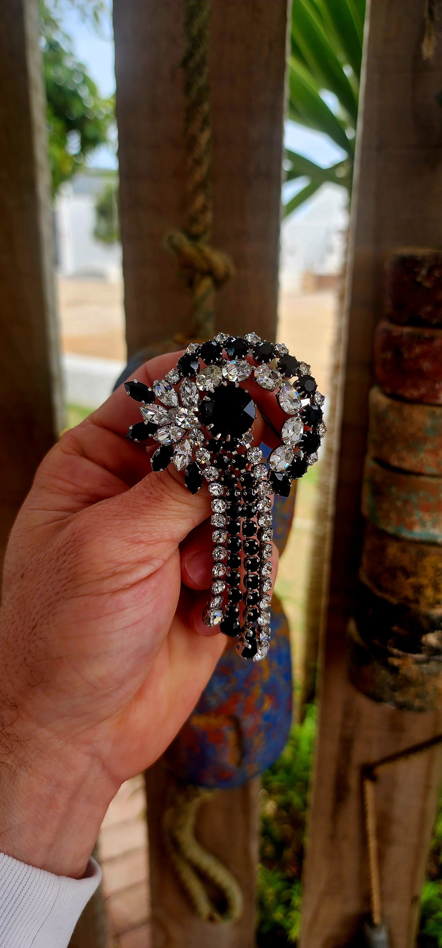This breathtaking Art Deco era brooch is an absolute showstopper — crafted in silvertone metal and lavishly adorned with prong-set crystal rhinestones in striking shades of jet black and brilliant clear..